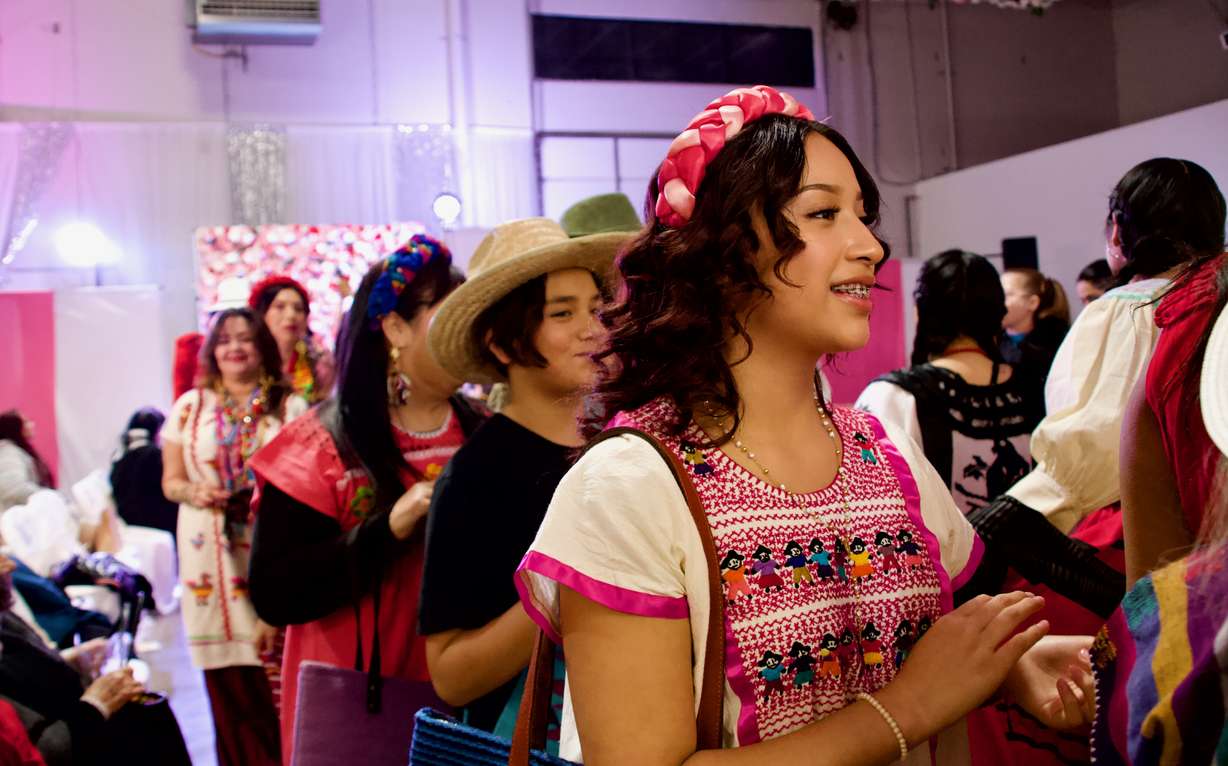 Frida Montero,13, walks down the runway. Frida Montero, 13, is Her outfit combines a traditional huipil dress with modern touches like gold hoops and sparkly chanclas.