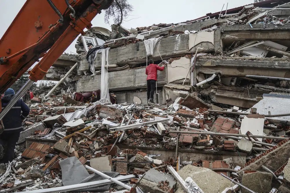 A man searches for people in the rubble of a destroyed building in Gaziantep, Turkey, Monday.