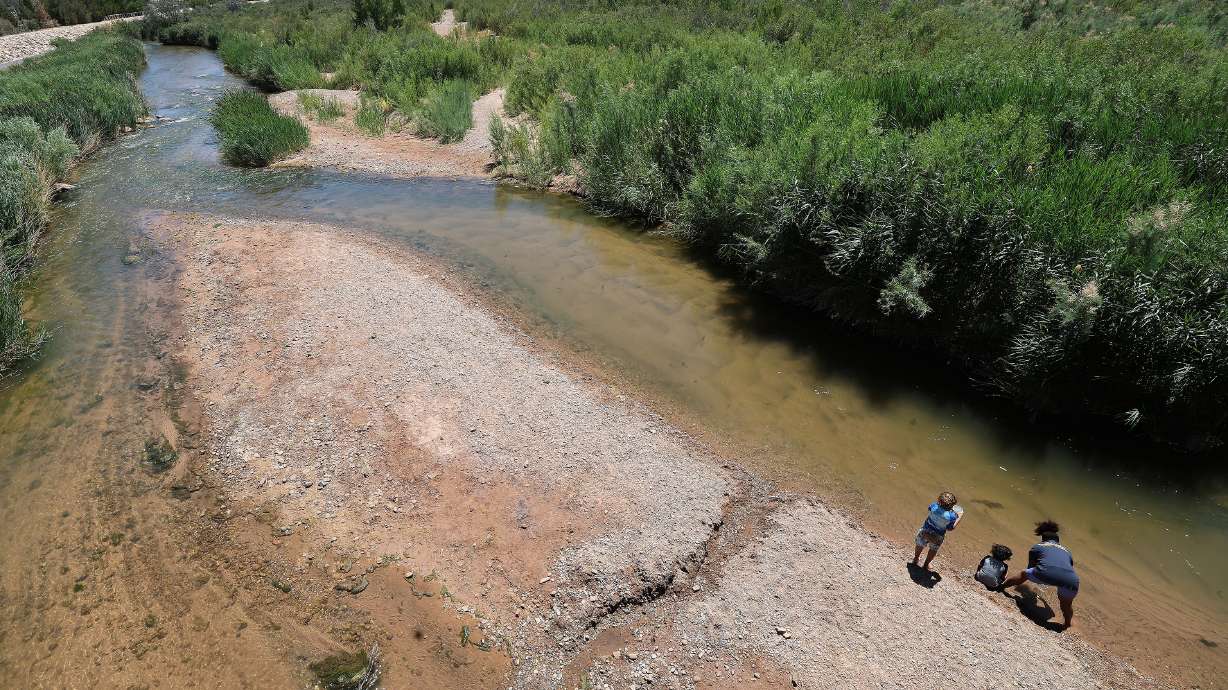 A woman and her children play in the Virgin River in St. George on June 10, 2022. St. George Mayor Michele Randall on Tuesday delivered the State of the City address with a major emphasis on water.