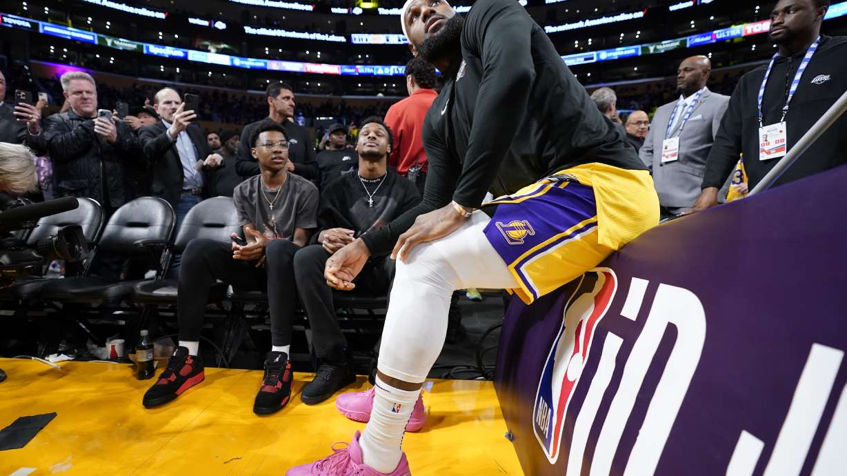 Los Angeles Lakers forward LeBron James talks with his kids prior to the second half of an NBA basketball game against the Oklahoma City Thunder Tuesday, Feb. 7, 2023, in Los Angeles.