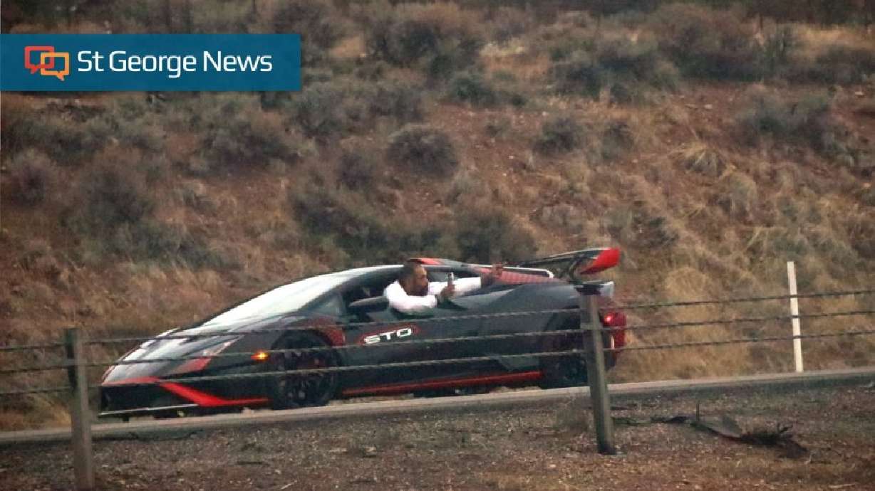 A driver who appears to be holding a cell phone points to responding officers as he leans out of a suspected stolen Lamborghini, Iron County, Utah, Dec. 31, 2022. Occupants of a Lamborghini pulled over by authorities on New Year's Eve have both reached plea agreements.