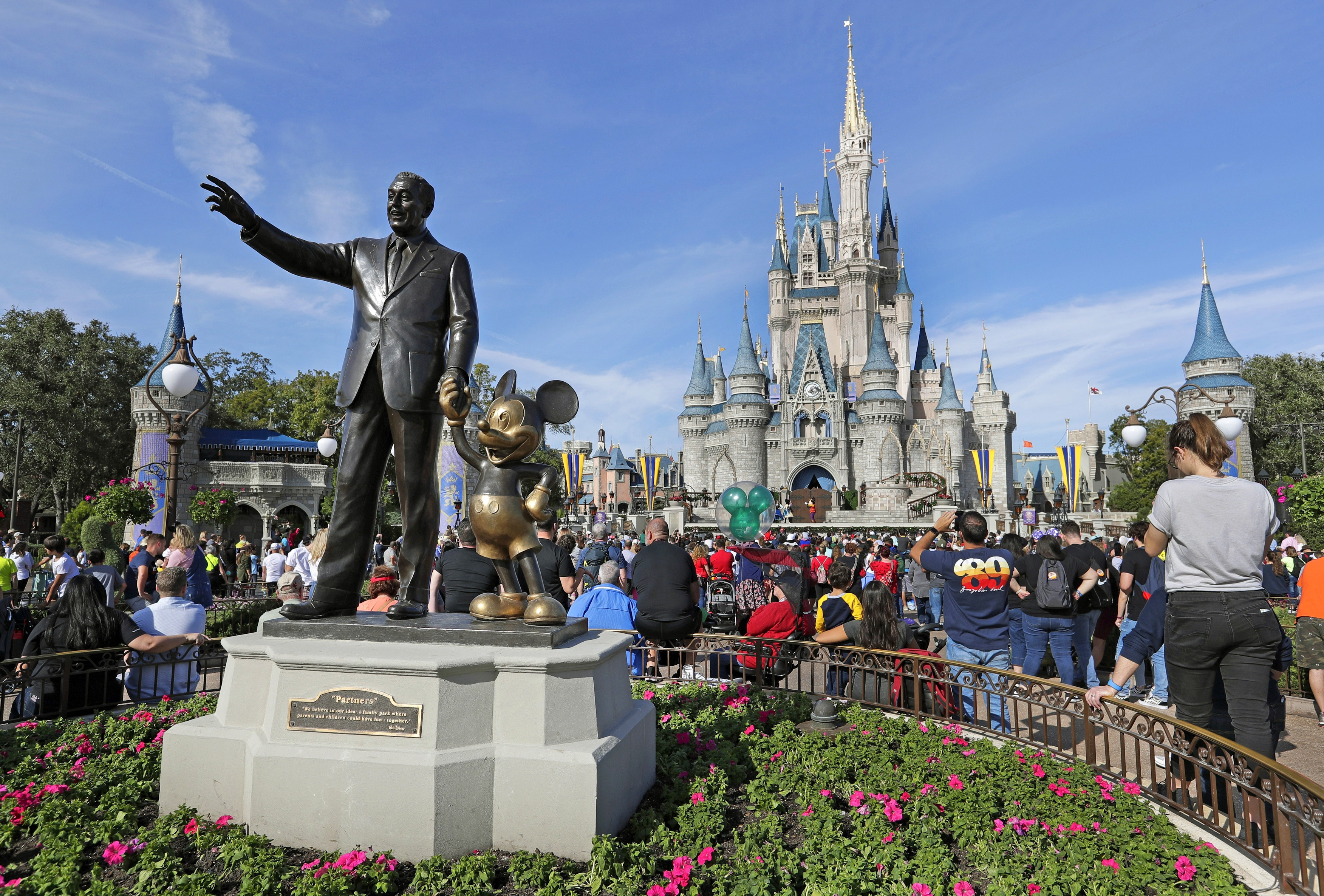 Guests watch a show near a statue of Walt Disney and Micky Mouse in front of the Cinderella Castle at the Magic Kingdom at Walt Disney World in Lake Buena Vista, Fla, Jan. 9, 2019. The Walt Disney Company reports its corporate results on Wednesday.