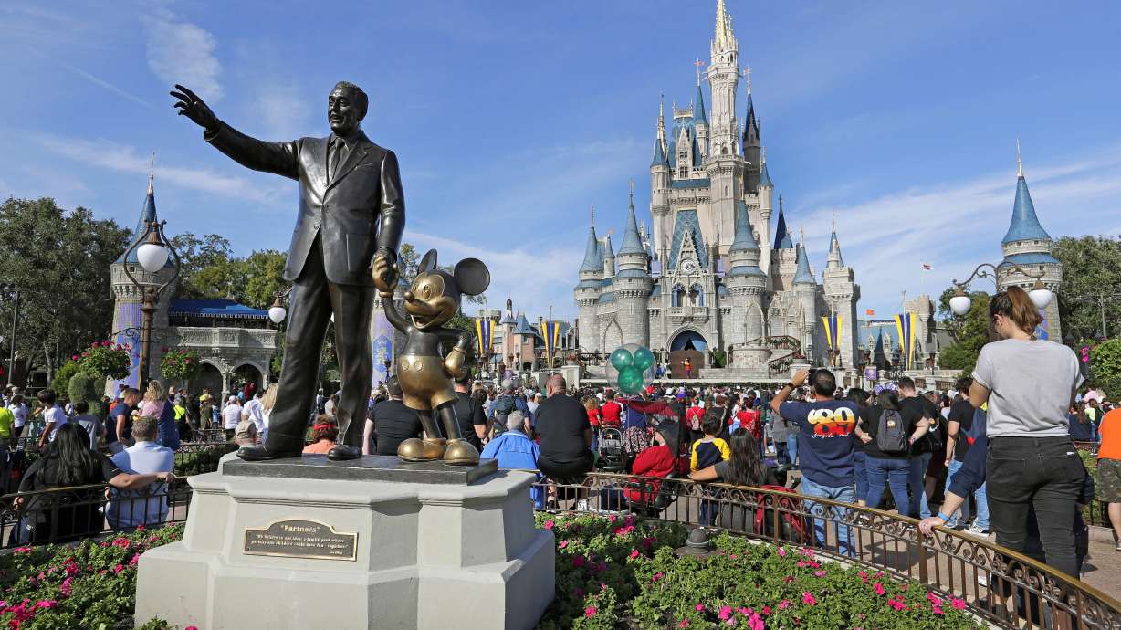 Guests watch a show near a statue of Walt Disney and Micky Mouse in front of the Cinderella Castle at the Magic Kingdom at Walt Disney World in Lake Buena Vista, Fla, Jan. 9, 2019. The Walt Disney Company reports its corporate results on Wednesday.