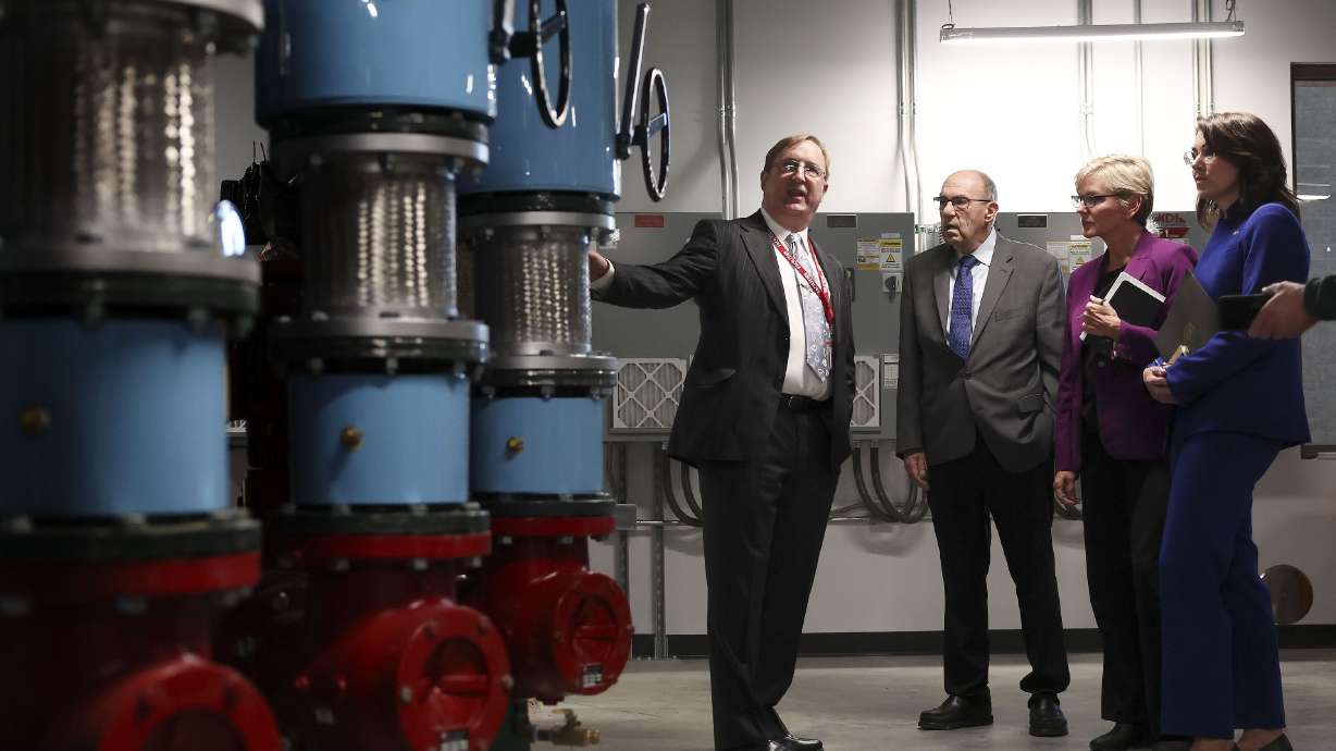 John Palo, facility manager at the University of Utah, left, speaks with Joseph Moore, managing principal investigator of the Utah FORGE site, U.S. Energy Secretary Jennifer M. Granholm and Lt. Gov. Deidre M. Henderson in the pump room of Gardner Commons at the University of Utah in Salt Lake City on Wednesday.