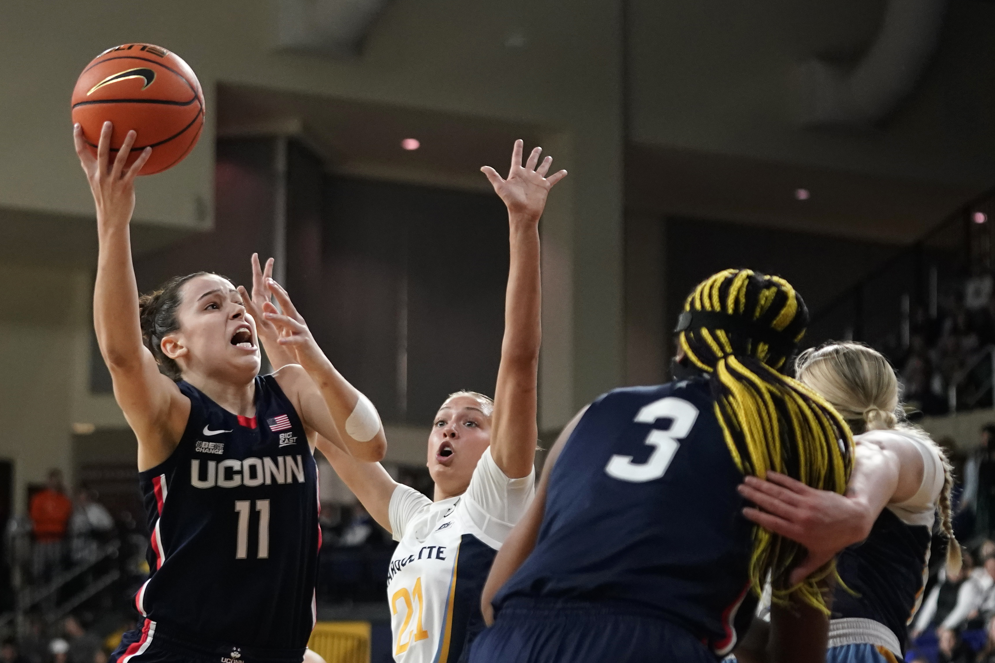 UConn's Lou Lopez Senechal (11) shoots past Marquette's Emily La Chapell during the first half of an NCAA college basketball game Wednesday, Feb. 8, 2023, in Milwaukee.