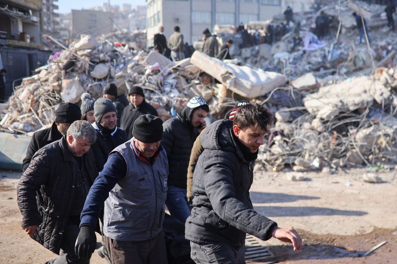 People carry the body of a victim removed from under the rubble in the aftermath of a deadly earthquake in Kahramanmaras, Turkey, Thursday. Turkey's decision to block access to Twitter for about 12 hours from Wednesday afternoon to early Thursday has compounded public frustration at the pace of relief efforts.