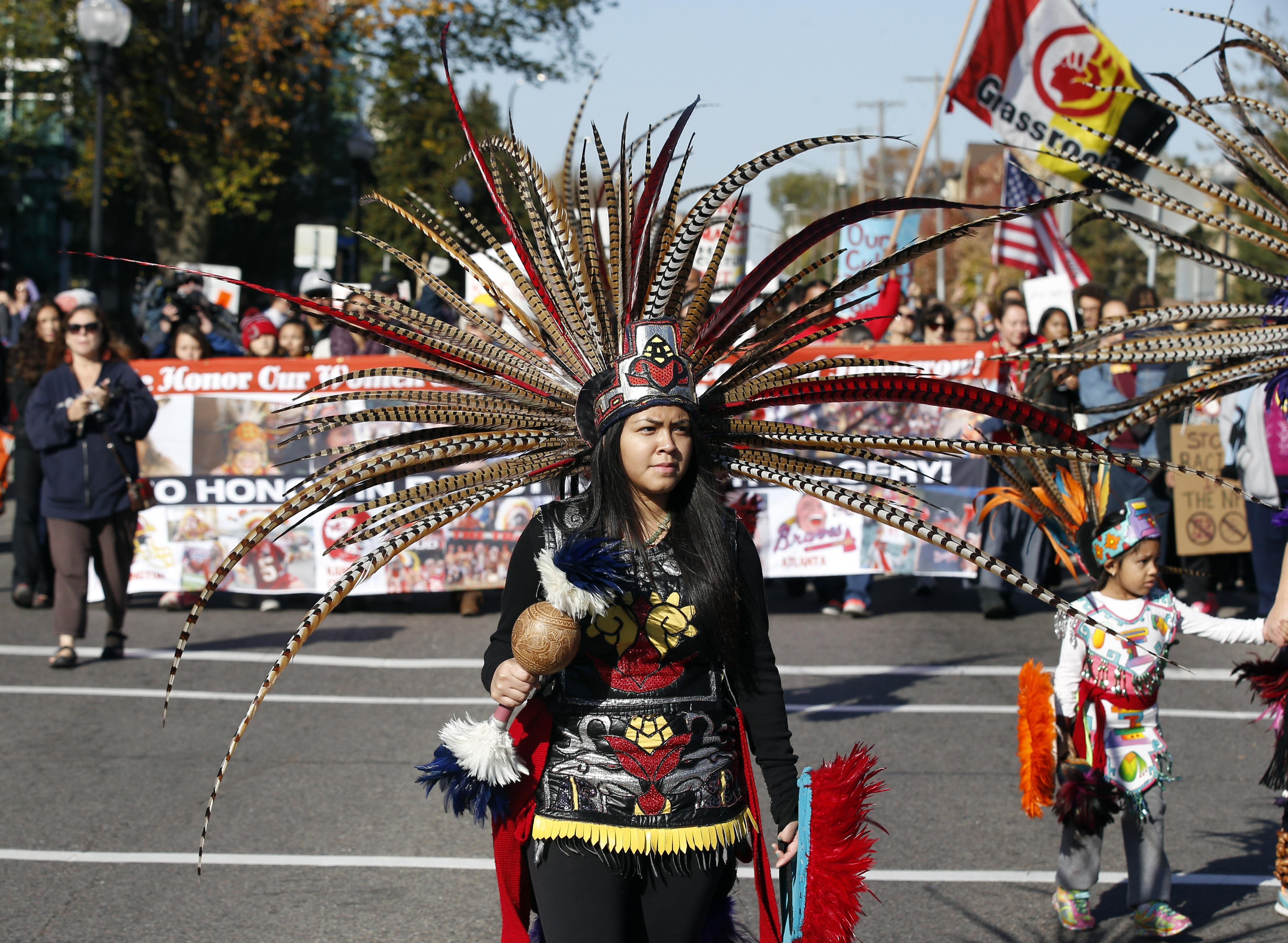 FILE - A woman wearing Native American clothing attends a "No Honor in Racism Rally" march in front of TCF Bank Stadium before an NFL football game between the Minnesota Vikings and the Kansas City Chiefs, Oct. 18, 2015, in Minneapolis. The group objects to the Kansas City Chiefs name, and other teams' use of Native Americans as mascots. As the Kansas City Chiefs return to Super Bowl on Sunday, Feb. 12, 2023, for the first time in two years, the movement to change their name and logo will be there again. 