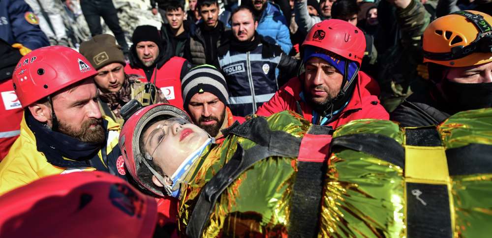 Rescuers carry Zeynep Polat, pulled out from a collapsed building days after the earthquake, in Kahramanmaras, southern Turkey, Thursday. Thinly stretched rescue teams worked through the night in Turkey and Syria, pulling more bodies from the rubble of thousands of buildings toppled by a catastrophic earthquake. 