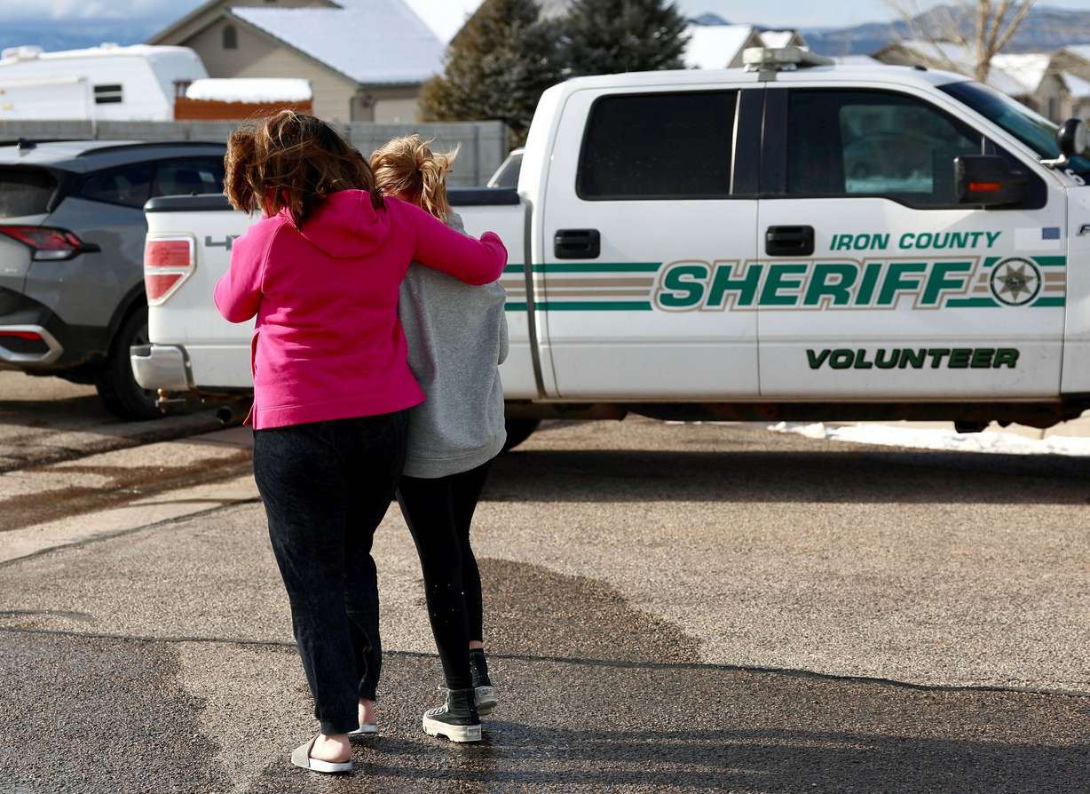 Alecia Jones, left, and her daughter Brooklyn, 13, leave after placing a Mini Mouse stuffed animal near police tape around a home where eight members of a family were killed in Enoch, Iron County, on Jan. 5. Brooklyn was friends with one of the victims.
