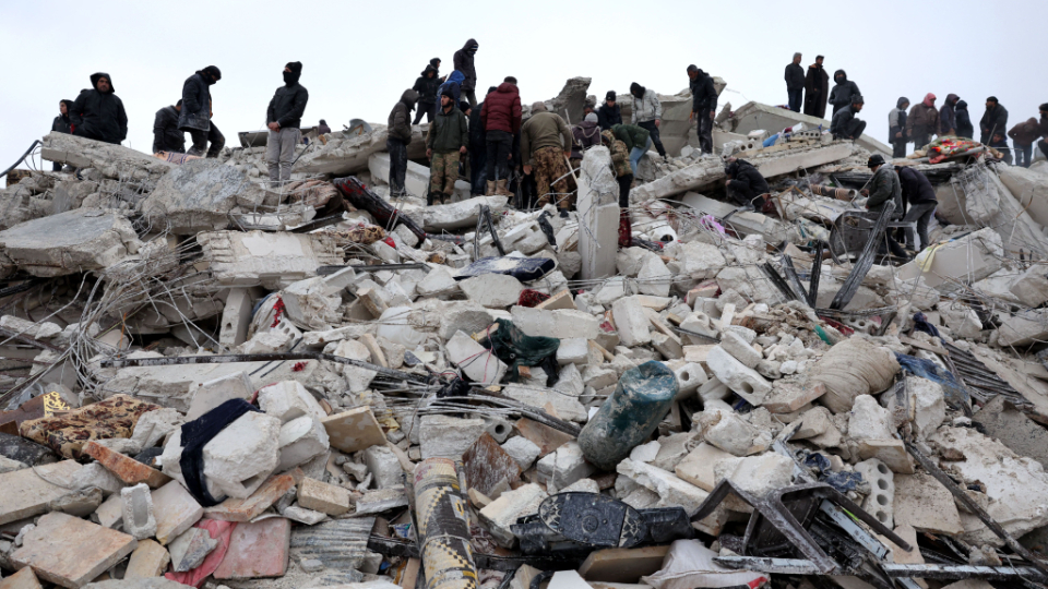 Residents and rescuers search for victims and survivors amid the rubble of collapsed buildings in the village of Besnaya in Syria northwestern Idlib province on the border with Türkiye following earthquakes on Monday.