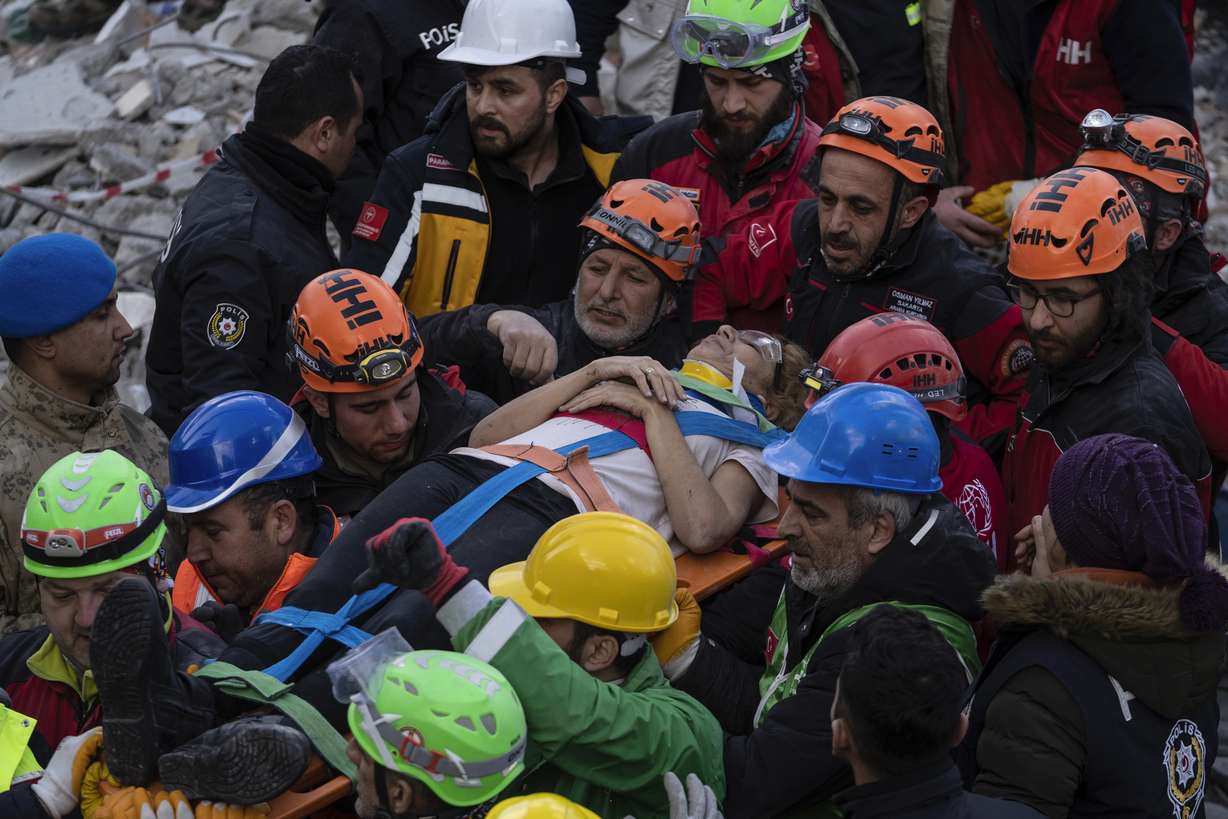 Raziye Kilinc is carried through a crowd on a stretcher after she was rescued under a destroyed building in Iskenderun, southeastern Turkey, Friday. A married couple was pulled from beneath the rubble of a collapsed building in Iskenderun after spending 109 hours buried within a small crevice.