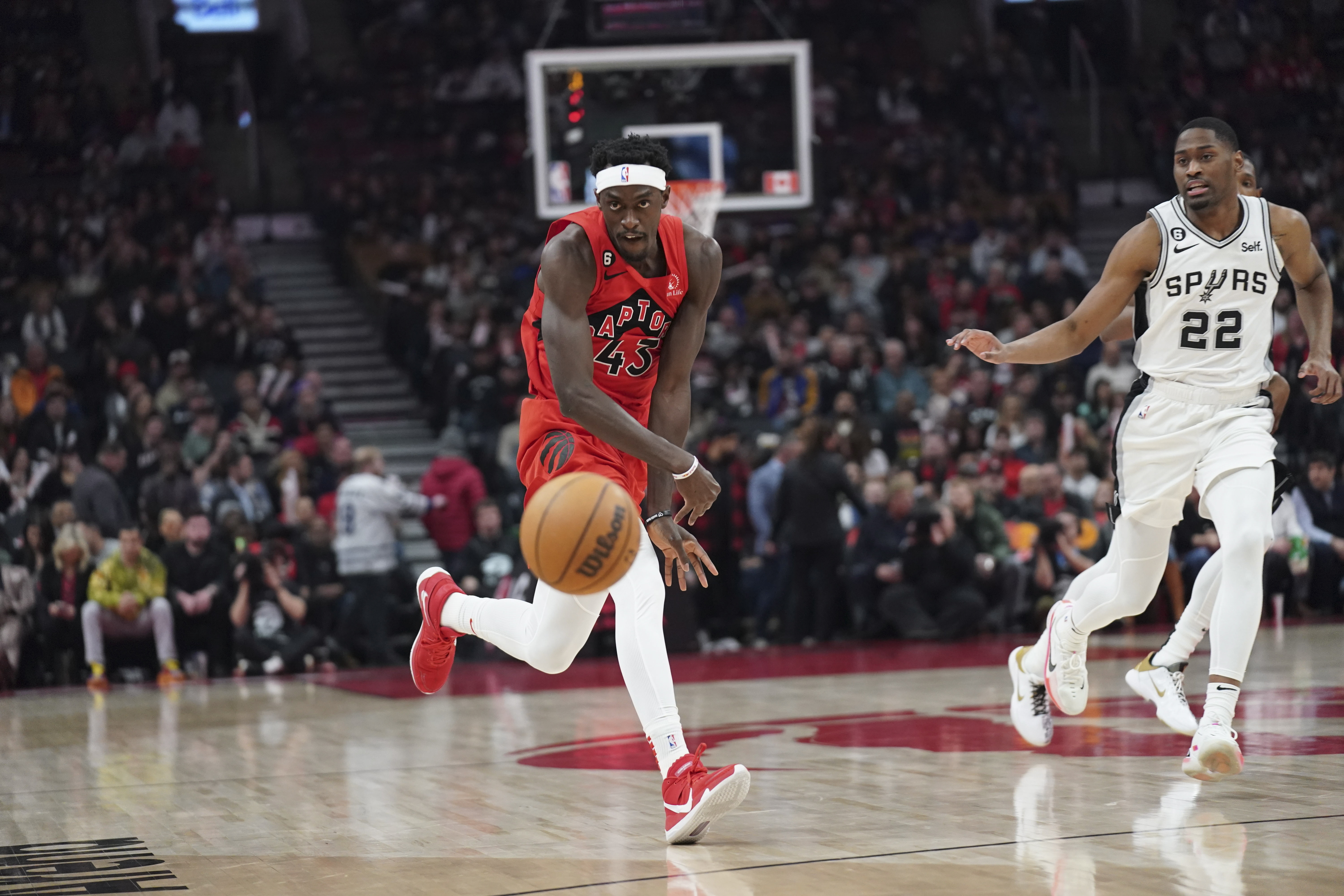 Toronto Raptors forward Pascal Siakam (43) passes the ball as San Antonio Spurs guard Malaki Branham (22) defends during the first half of an NBA basketball game Wednesday, Feb. 8, 2023, in Toronto. 