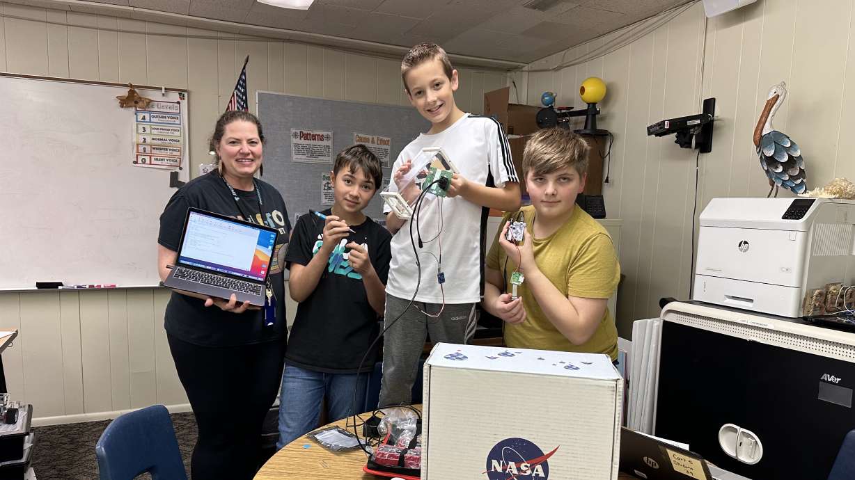 Parkside Elementary School teacher Rachel Grindstaff and students Thurl Brown, William O'Neill and Tanner Hawkes hold up pieces of the experiment they are building for NASA on Wednesday.
