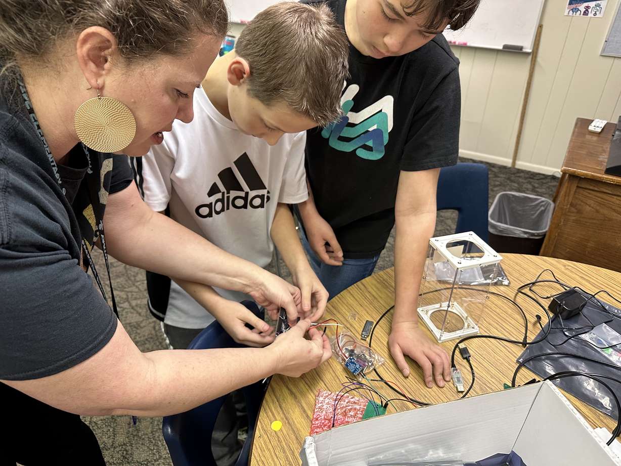 Parkside Elementary students Willliam O'Neill and Thurl Brown get help from their teacher Rachel Grindstaff as they put some wiring together on an experiment on Wednesday.
