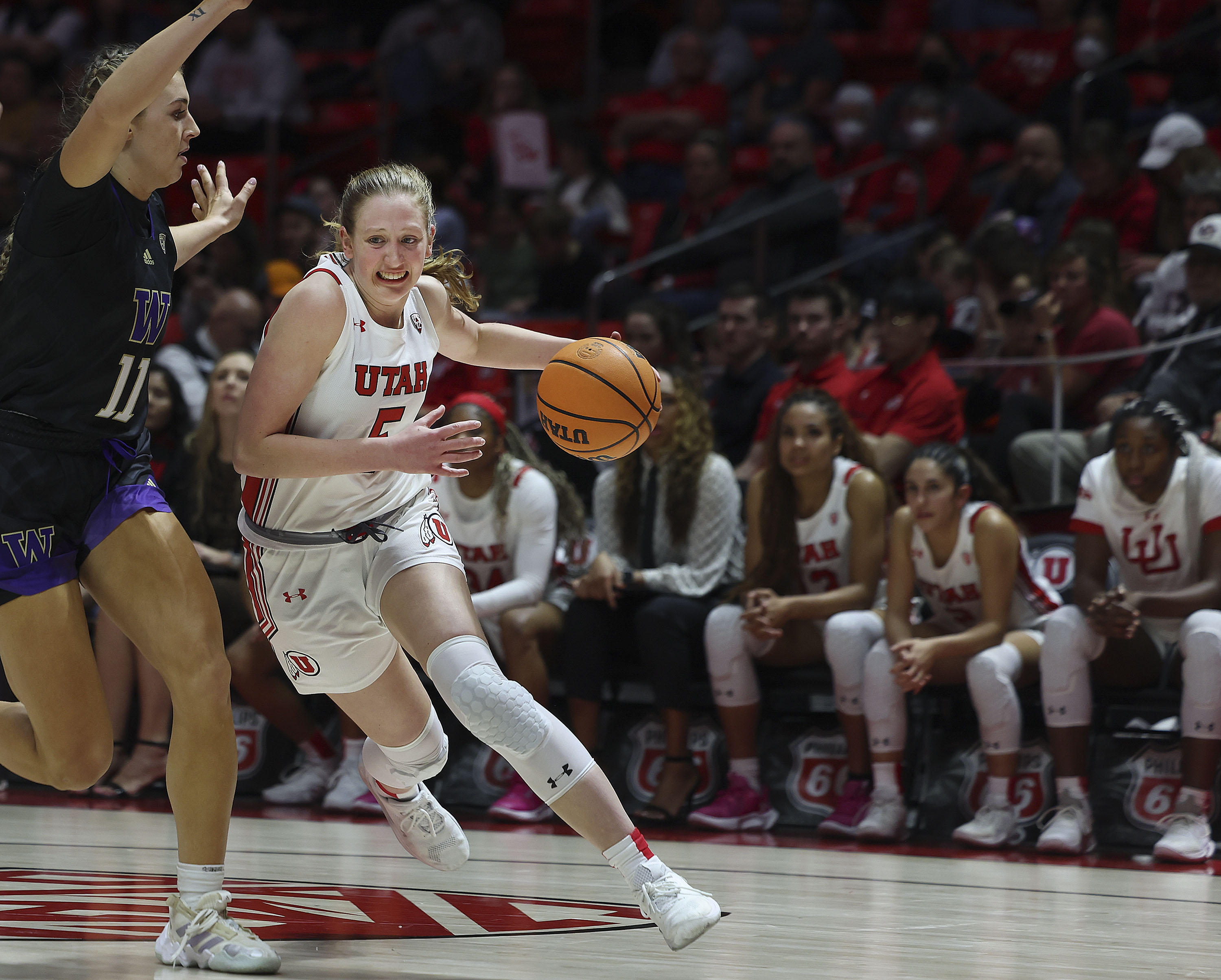 Utah Utes guard Gianna Kneepkens (5) drives against Washington Huskies forward Haley Van Dyke (11) at the Jon M. Huntsman Center in Salt Lake City on Friday, Feb. 10, 2023.