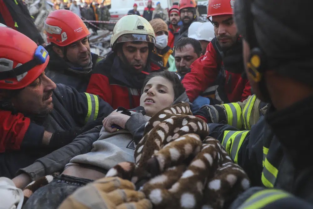 Rescuers carry Muhammed Alkanaas, 12, to an ambulance after they pulled him out five days after the Monday earthquake in Antakya, southern Turkey, late Saturday.