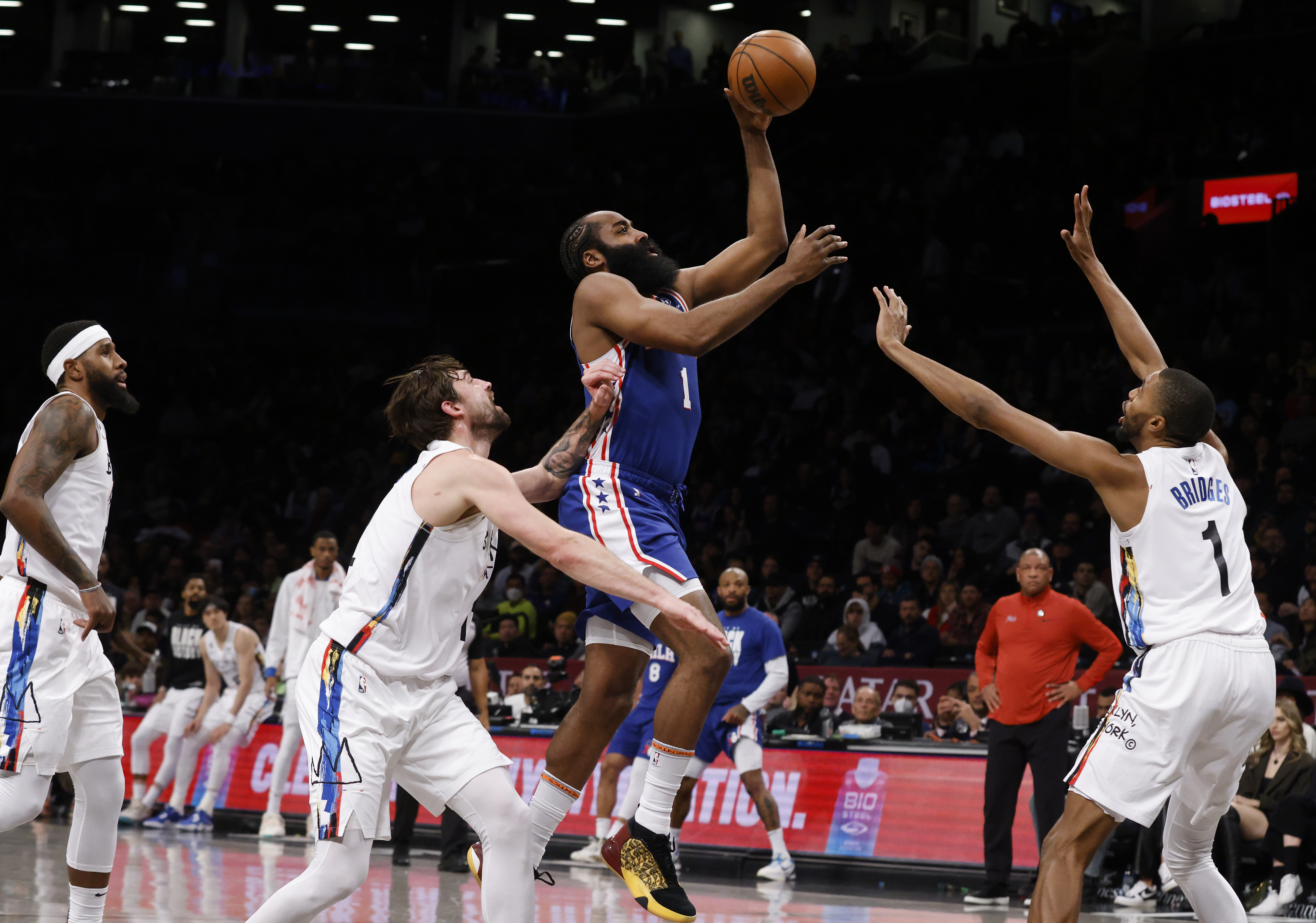 Philadelphia 76ers' James Harden, center, shoots against Brooklyn Nets' Joe Harris, second from left, and Mikal Bridges, right, during the second quarter of an NBA basketball game Saturday, Feb. 11, 2023, in New York. 