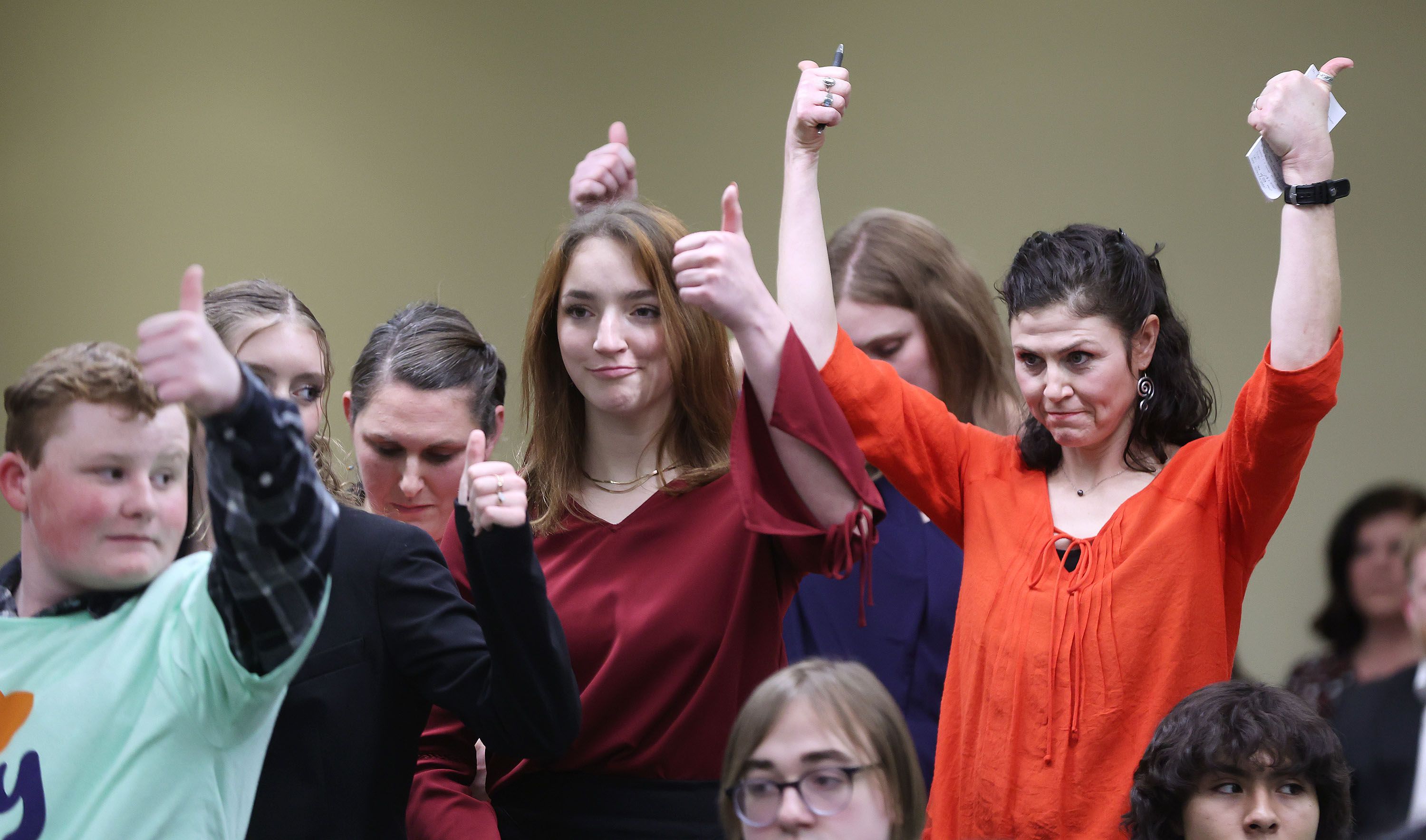Elissa Ludlum, right, and others give a thumbs-up after hearing a public comment during a House Education Committee hearing concerning HB215 at the Capitol in Salt Lake City on Jan. 19. The bill would create the Utah Fits All Scholarships, which would link a teacher salary increase to a “school choice” program.