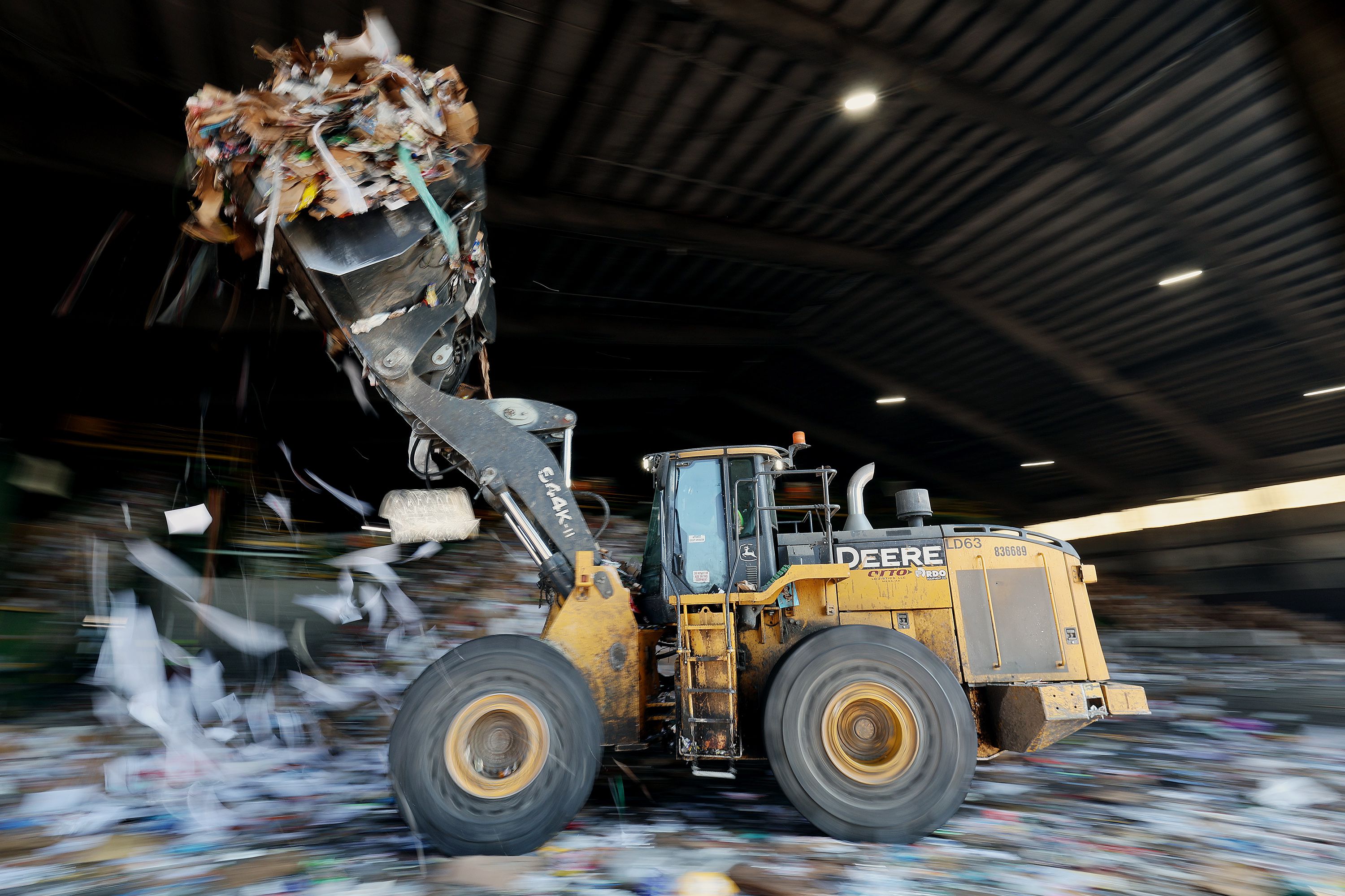 A worker uses a loader to fill a giant hopper with recycling products at the Waste Management sorting center in Salt Lake City on Monday. An international report released this month found efforts to recycle single-use plastic waste are failing miserably and not keeping pace with production, creating more oceanic waste and material buried in landfills.