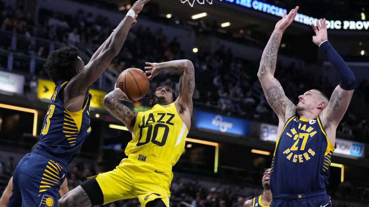 Utah Jazz guard Jordan Clarkson (00) is fouled as he shoots between Indiana Pacers forward Jordan Nwora (13) and center Daniel Theis (27) during the second half of an NBA basketball game in Indianapolis, Monday, Feb. 13, 2023. The Jazz defeated the Pacers 123-117.
