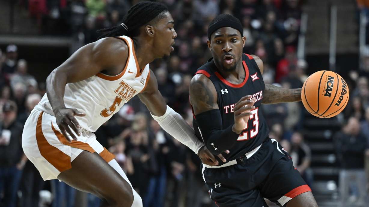Texas Tech guard De'Vion Harmon (23) brings the ball upcourt against Texas guard Marcus Carr (5) during the first half of an NCAA college basketball game, Monday, Feb. 13, 2023, in Lubbock, Texas.