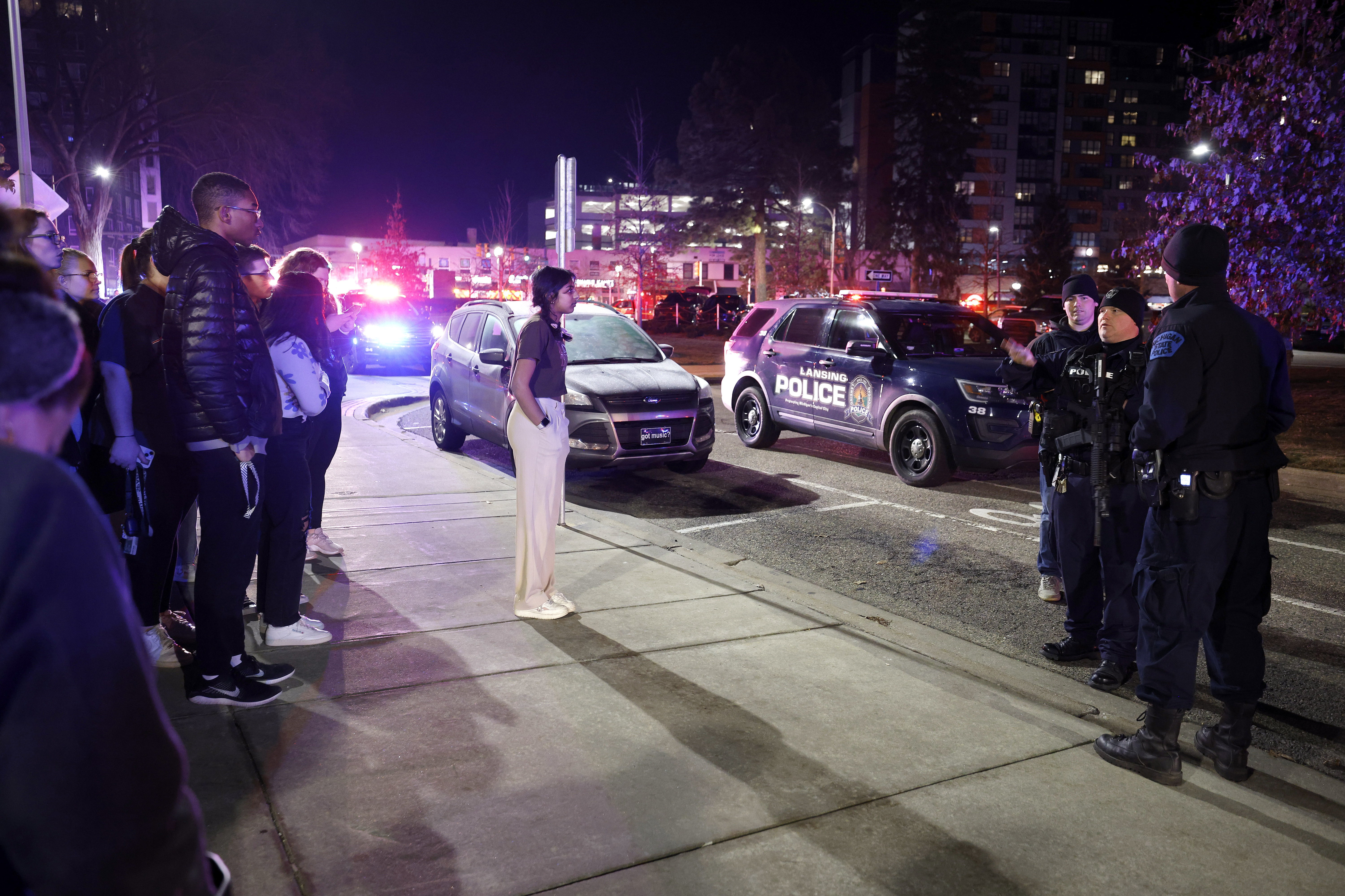 Students get directions from police on the campus of Michigan State University after a shelter in place order was lifted early Tuesday, in East Lansing, Mich.