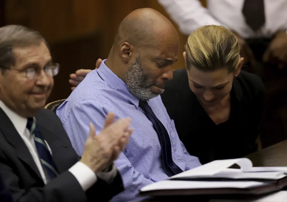 Lamar Johnson, center and his attorneys react on Tuesday after St. Louis Circuit Judge David Mason vacated his murder conviction during a hearing in St. Louis, Mo. Johnson served nearly 28 years of a life sentence for a killing that he has always said he didn't commit.