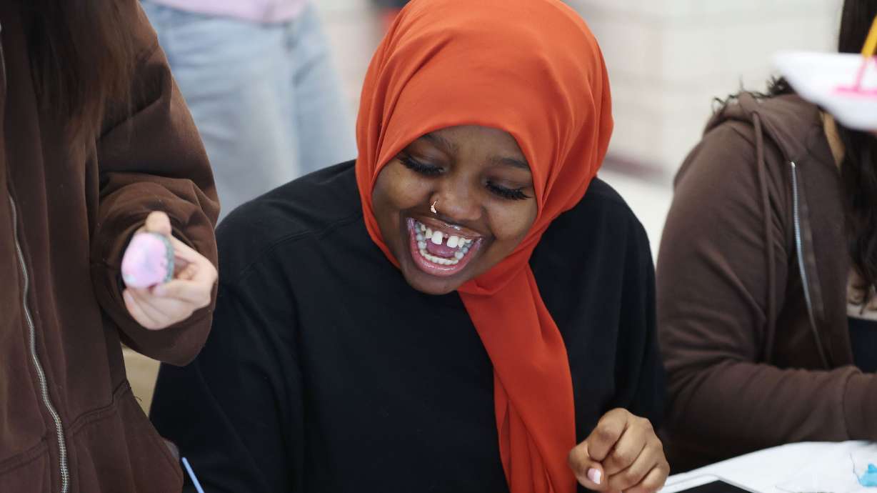 East High School student Fadumo Aden has fun painting a rock that has a kind message on it in Salt Lake City on Tuesday. Students participated in the community outreach project focused on kindness.