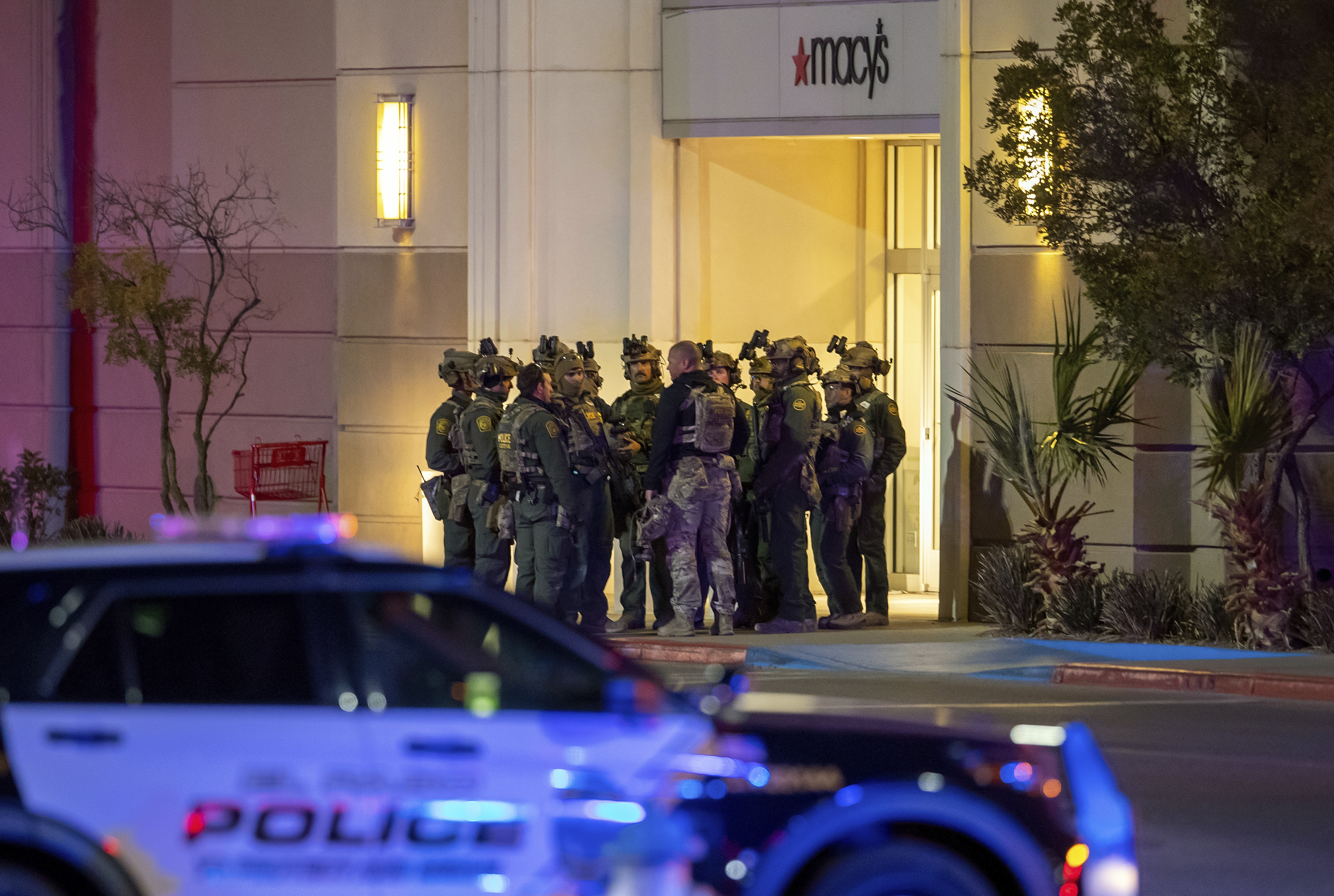 Police officers gather at an entrance of a shopping mall, Wednesday, in El Paso, Texas. Police say one person was killed and three other people were wounded in a shooting at Cielo Vista Mall.