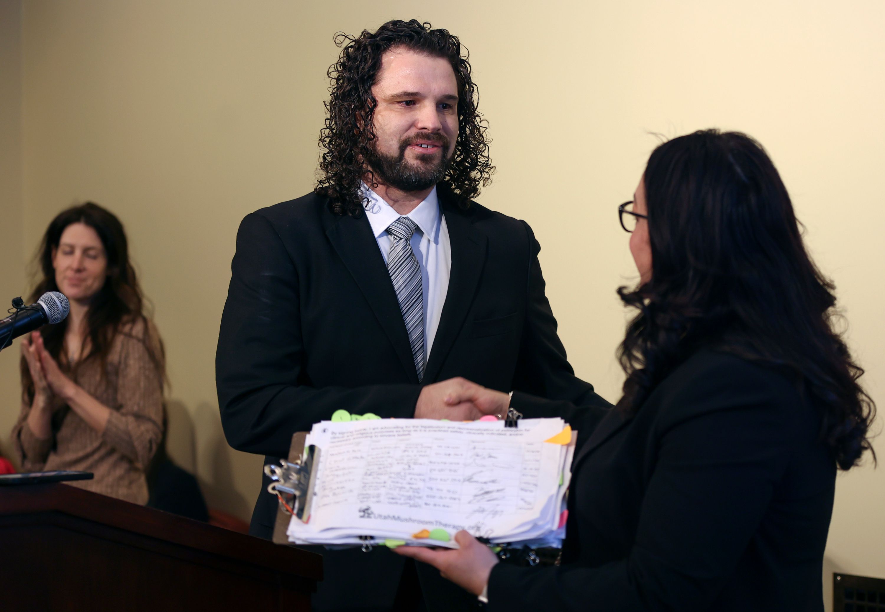 Bridger Jensen, Utah Psilocybin Therapy’s executive director, gives Sen. Luz Escamilla, D-Salt Lake City, a stack of signed petitions in support of SB200, Utah psilocybin therapy, during a press conference at the Capitol in Salt Lake City, on Wednesday. Around 5,000 people had signed the petition to show their support, organizers said.