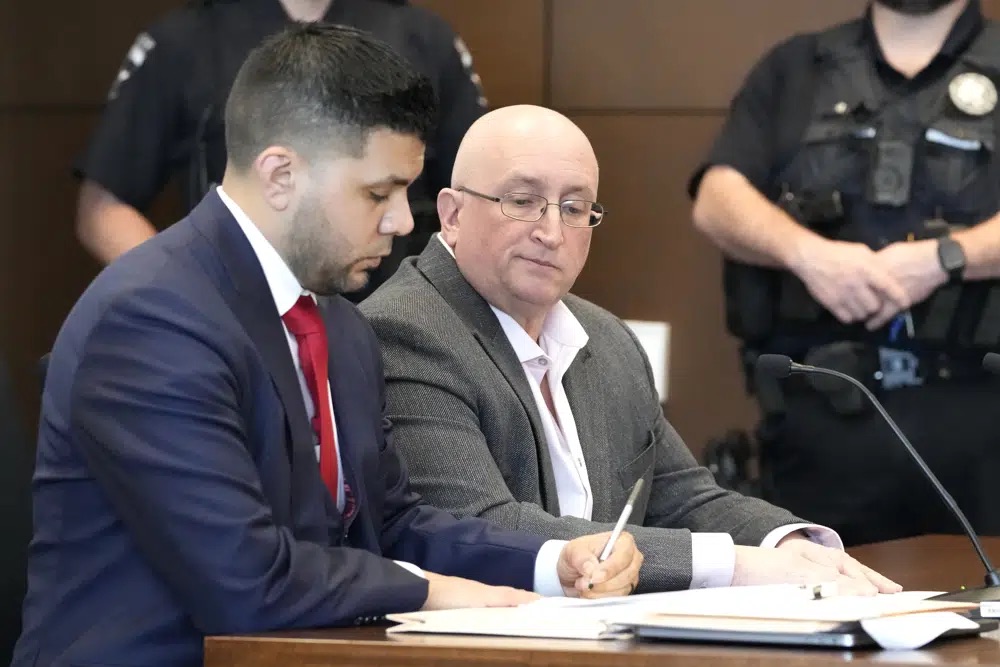 Robert E. Crimo Jr., right, sits with his George Gomez at the Lake County Courthouse, Thursday, in Waukegan, Ill. Crimo entered a plea of not guilty to charges that he helped his son obtain a gun license.