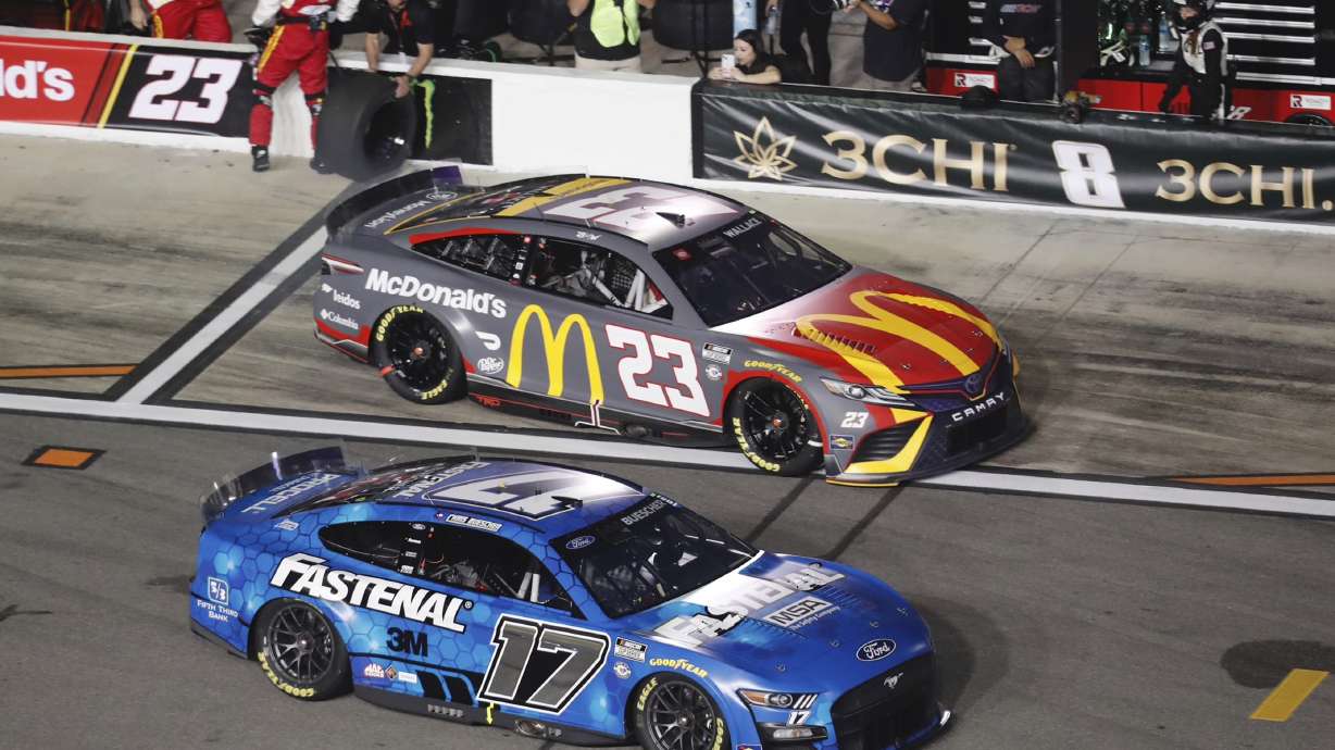 Chris Buescher (17) jumps ahead of Bubba Wallace (23) after a pit stop during the first of two qualifying auto races for the NASCAR Daytona 500 at Daytona International Speedway, Thursday, Feb. 16, 2023, in Daytona Beach, Fla.