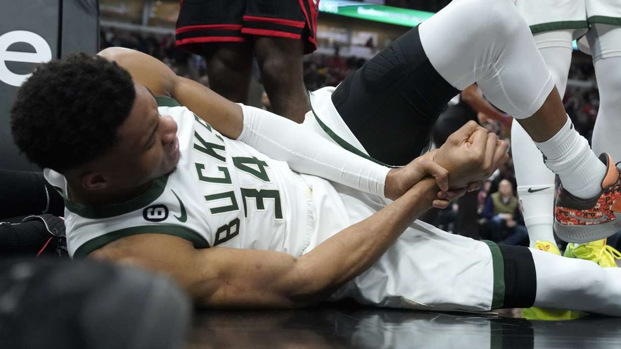 Milwaukee Bucks' Giannis Antetokounmpo lies by the basket after injuring his right wrist during the first half of the team's NBA basketball game against the Chicago Bulls on Thursday, Feb. 16, 2023, in Chicago.