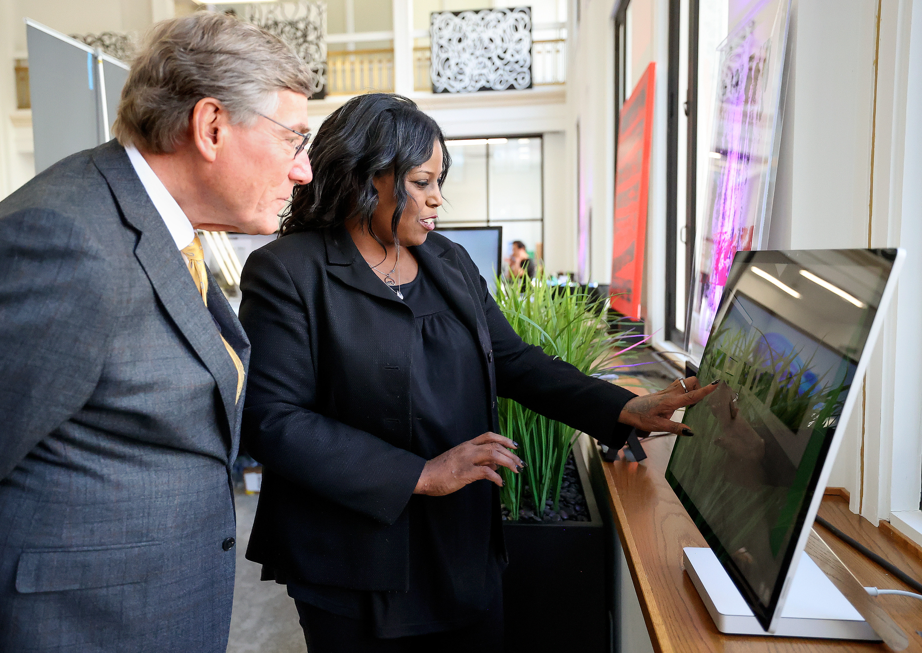 Nikki Walker, Utah Black Chamber of Commerce publicity chair, shows Zions Bank president and CEO Scott Anderson part of Black Museum Utah’s digital interactive exhibit in Salt Lake City on Thursday.