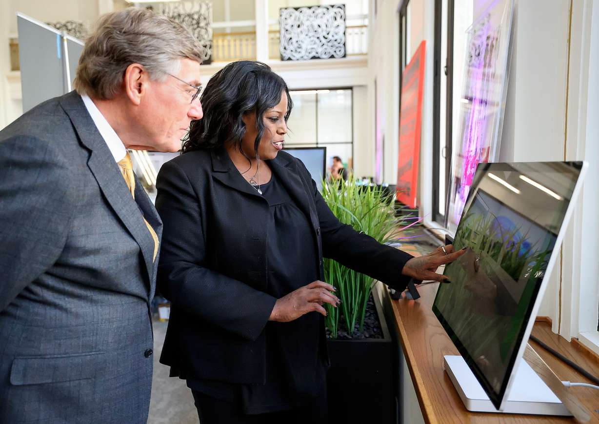 Nikki Walker, Utah Black Chamber of Commerce publicity chair, shows Zions Bank president and CEO Scott Anderson part of Black Museum Utah’s digital interactive exhibit in Salt Lake City on Thursday.