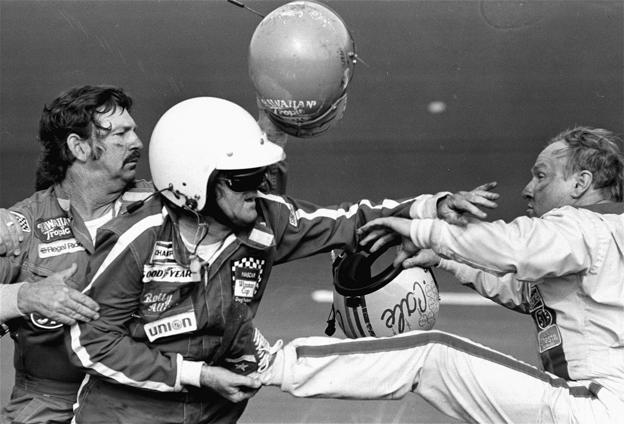 FILE - Bobby Allison, center, holds race driver Cale Yarborough's foot after Yarborough, right, kicked him following the Daytona 500 auto race in Daytona Beach, Fla., Feb. 18, 1979. 
