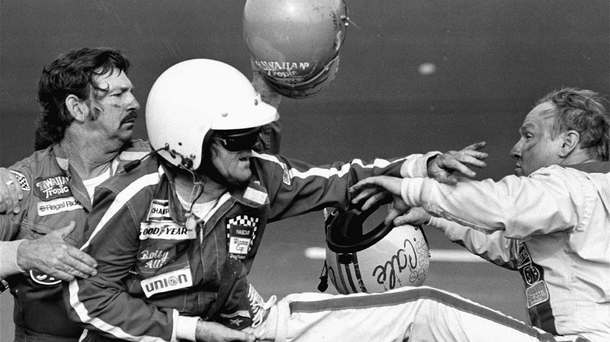 FILE - Bobby Allison, center, holds race driver Cale Yarborough's foot after Yarborough, right, kicked him following the Daytona 500 auto race in Daytona Beach, Fla., Feb. 18, 1979.