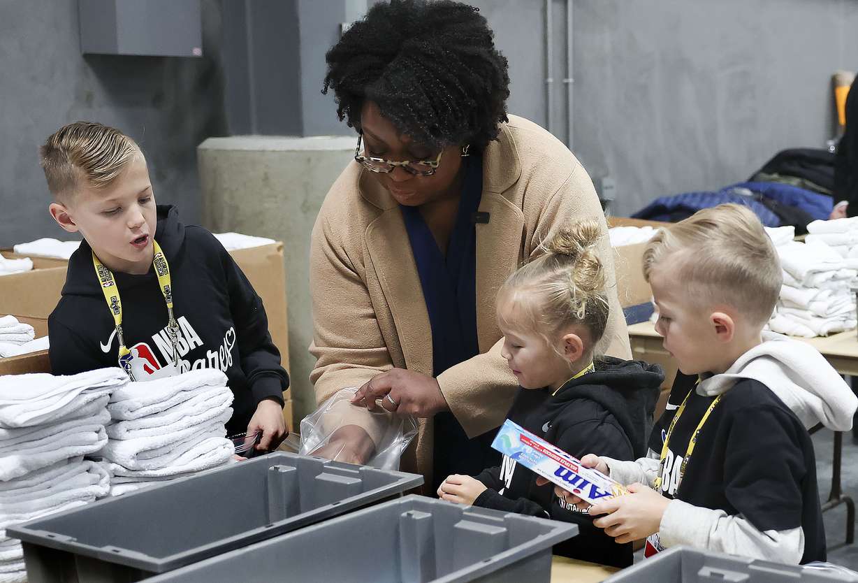 Sister Tracy Y. Browning, second counselor in the Primary general presidency for The Church of Jesus Christ of Latter-day Saints, packs up toiletry kits with Jet, Violet and Jude Smith at the Bishops' Central Storehouse in Salt Lake City on Friday as part of the NBA Cares All-Star Day of Service.