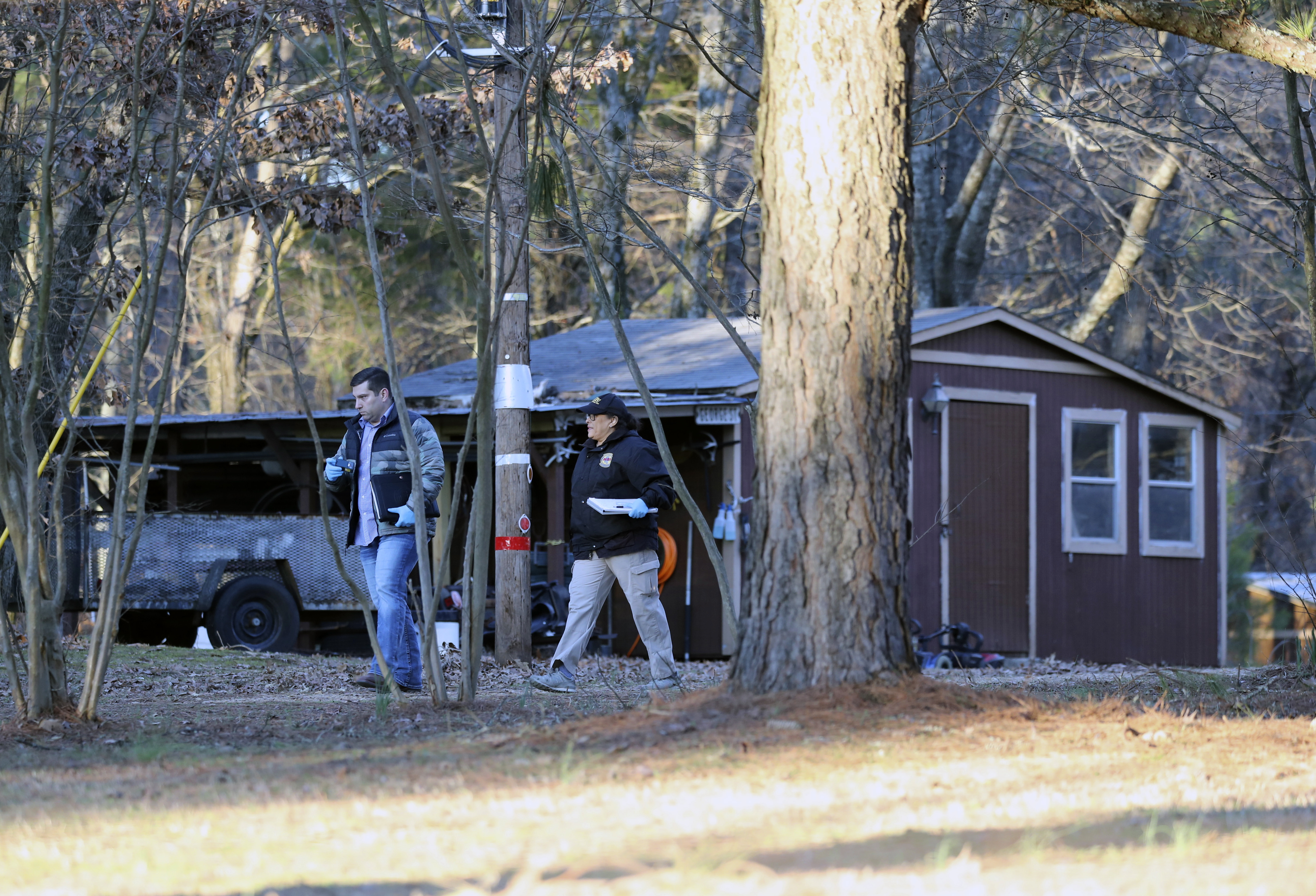 Law enforcement personnel investigate the scene of multiple shootings on Arkabutla Dam Road in Arkabutla, Miss on Friday.