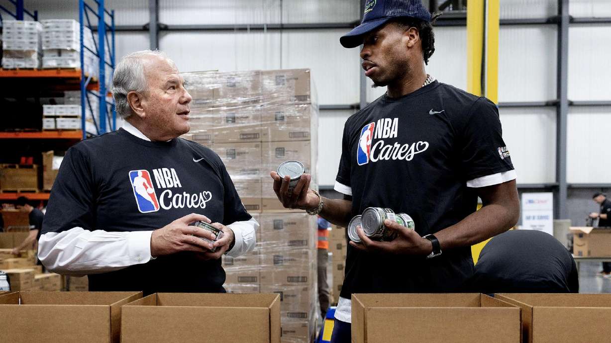 Elder Ronald A. Rasband, a member of the Quorum of the Twelve Apostles of The Church of Jesus Christ of Latter-day Saints, chats with Indiana Pacers’ Buddy Hield as they sort and pack food donations to distribute to low-income students and families at the Bishops' Central Storehouse in Salt Lake City on Friday as part of the NBA Cares day of service.