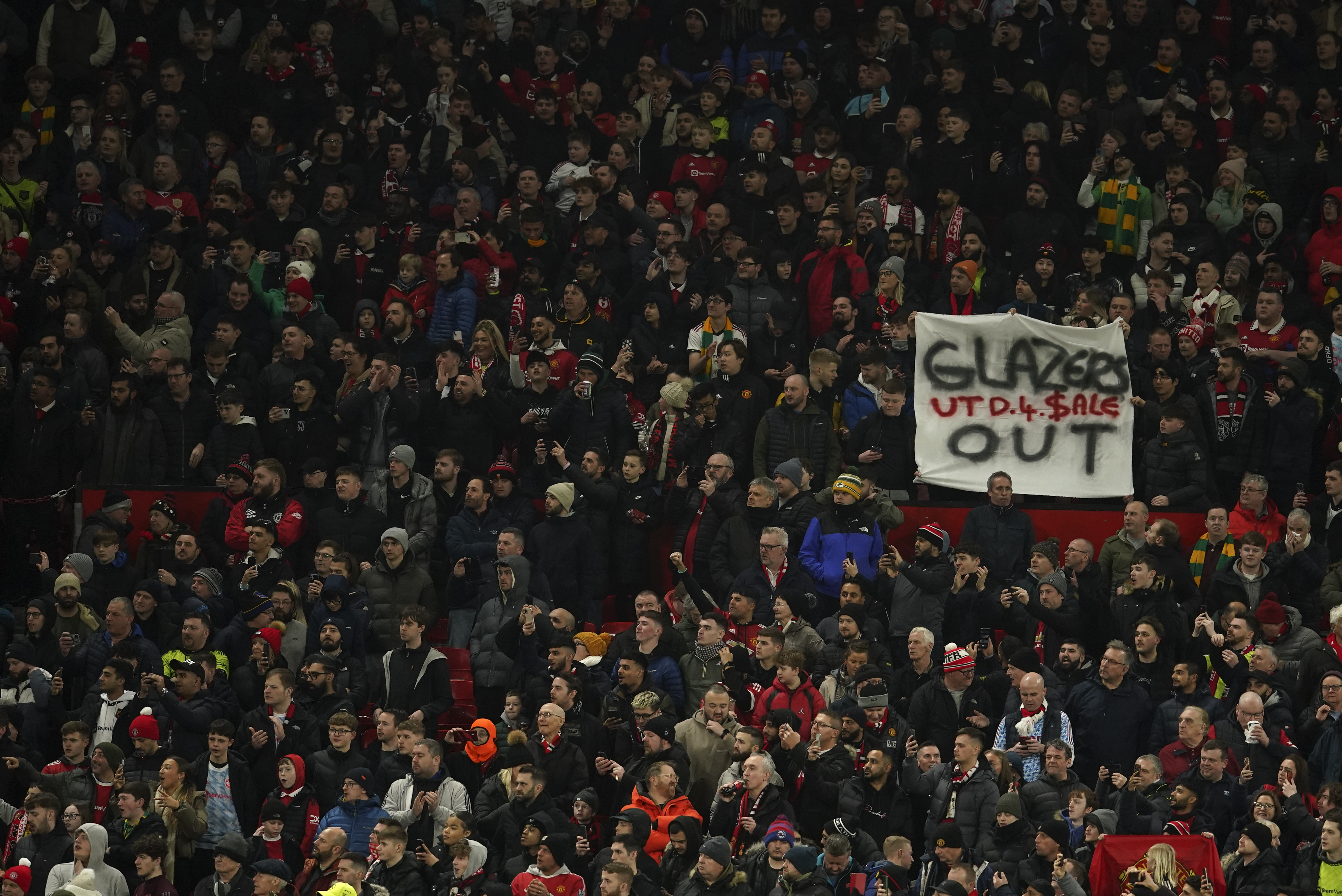 An anti-Glazer family banner is held up by members of the crowd before the English League Cup semifinal second leg soccer match between Manchester United and Nottingham Forest at Old Trafford in Manchester, England, Wednesday, Feb. 1, 2023. The Glazer family are the owners of Manchester United. 