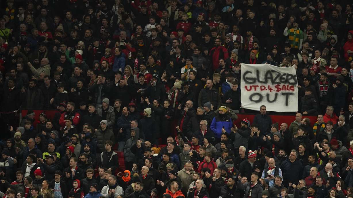 An anti-Glazer family banner is held up by members of the crowd before the English League Cup semifinal second leg soccer match between Manchester United and Nottingham Forest at Old Trafford in Manchester, England, Wednesday, Feb. 1, 2023. The Glazer family are the owners of Manchester United.