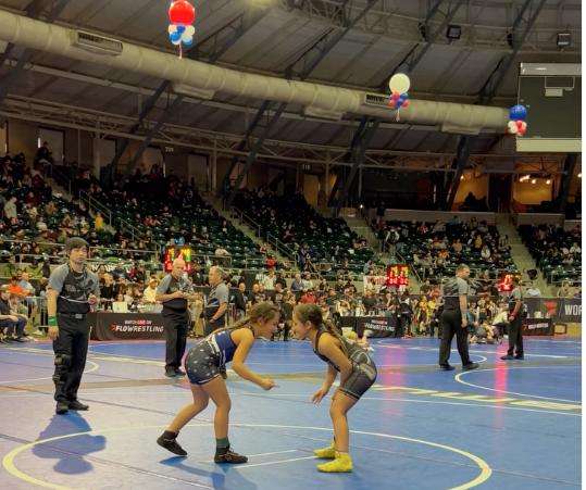 Twin sisters Line and Losa Nau Rarick, who are 7, face off at the national championship wrestling match earlier this year. Losa, who won last year, gave up to give her sister the title.