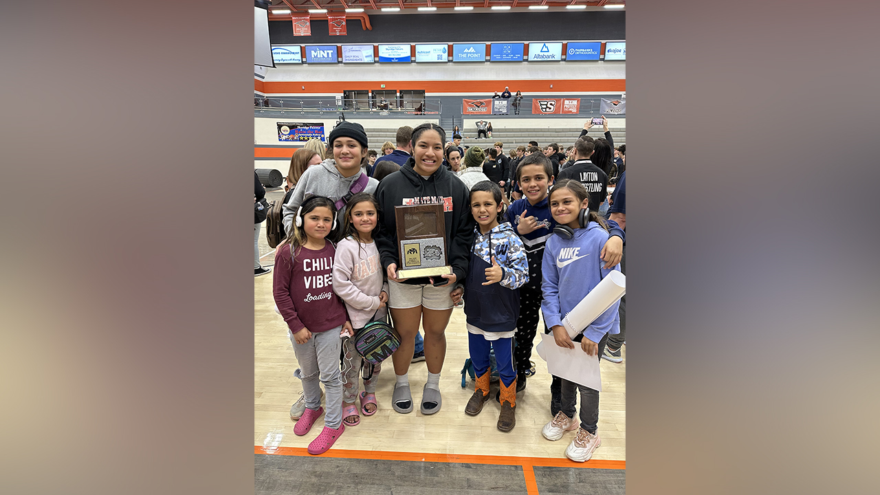 Siblings Losa, Line, Tevia, Kelikki, Bubs, Mani and Laker Nau Rarick, of Saratoga Springs, pose following the state championship wrestling match where Kelikki won on Wednesday, Feb. 16.