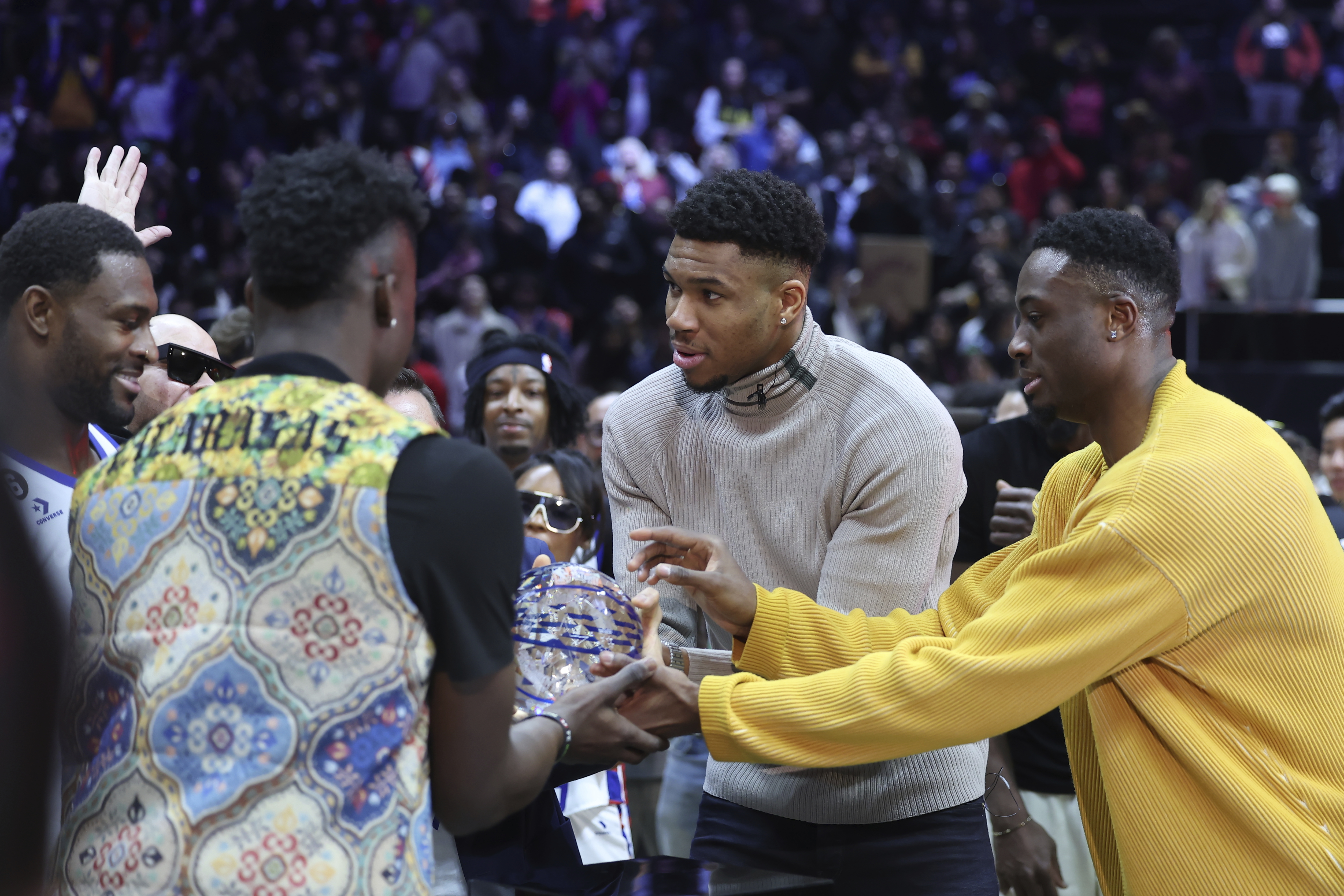 Millwaukee Bucks' Giannis Antetokounmpo, center, along with brothers Thanasis Antetokounmpo, right, and Alex Antetokounmpo award NFL player DK Metcalf the MVP award at the NBA All-Star Celebrity Game on Friday, Feb. 17, 2023, in Salt Lake City. 