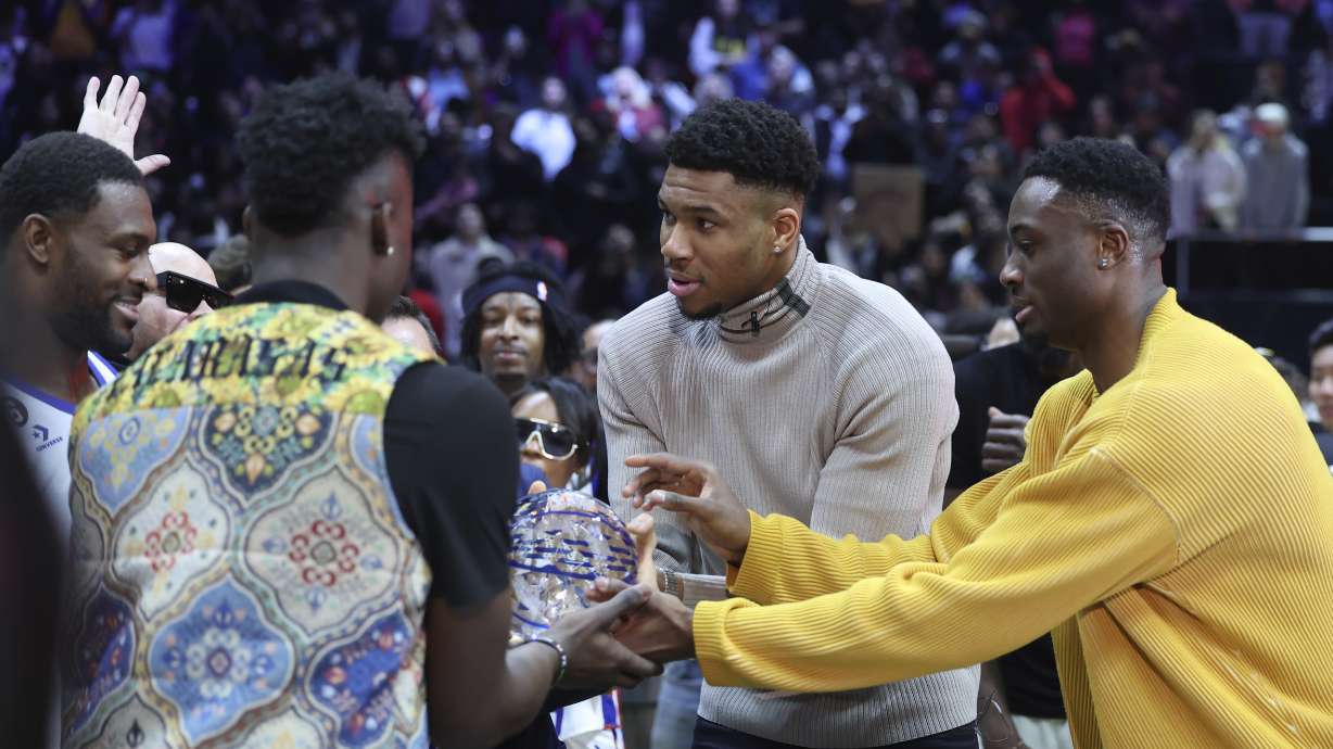 Millwaukee Bucks' Giannis Antetokounmpo, center, along with brothers Thanasis Antetokounmpo, right, and Alex Antetokounmpo award NFL player DK Metcalf the MVP award at the NBA All-Star Celebrity Game on Friday, Feb. 17, 2023, in Salt Lake City.