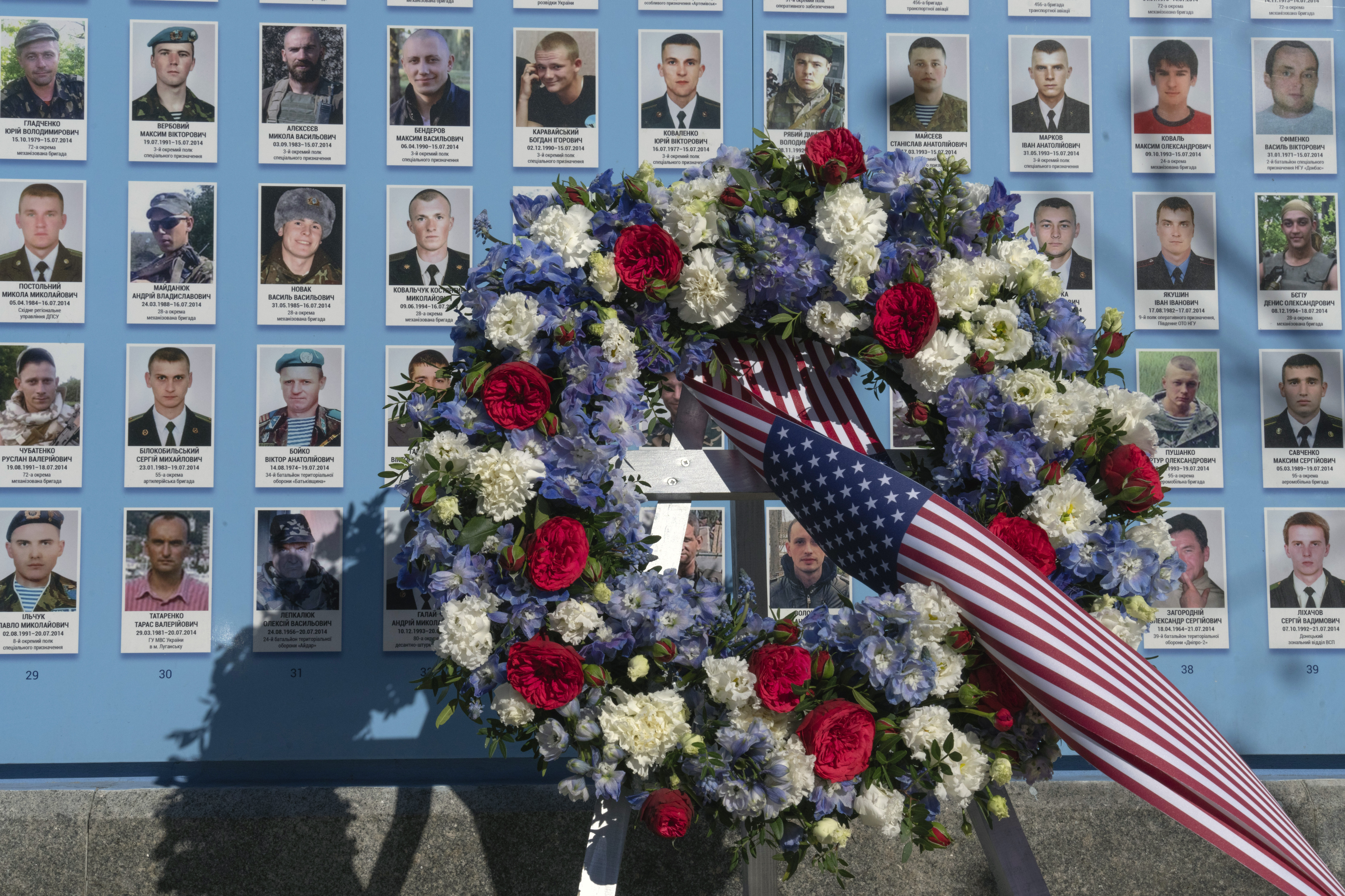 Flowers placed by the President Joe Biden at the Memorial Wall of Fallen Defenders of Ukraine in Russian-Ukrainian War with photos of killed soldiers in Kyiv, Ukraine, Monday.