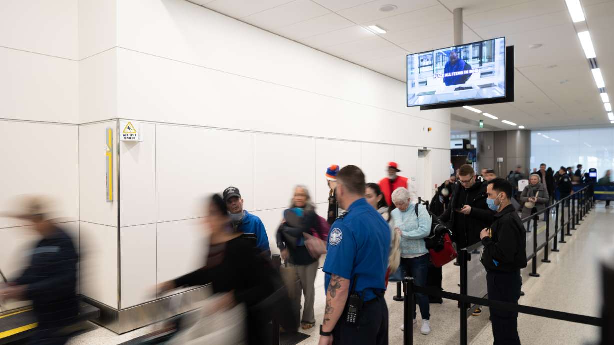 Travelers walk past security at Salt Lake City International Airport in Salt Lake City on Monday.