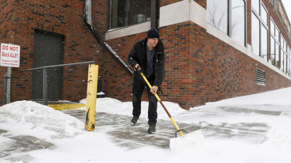David Smith shovels the sidewalk as the first snow falls ahead of a winter storm on Tuesday in Sioux Falls, S.D. A wide swath of the Upper Midwest is bracing for a historic winter storm.