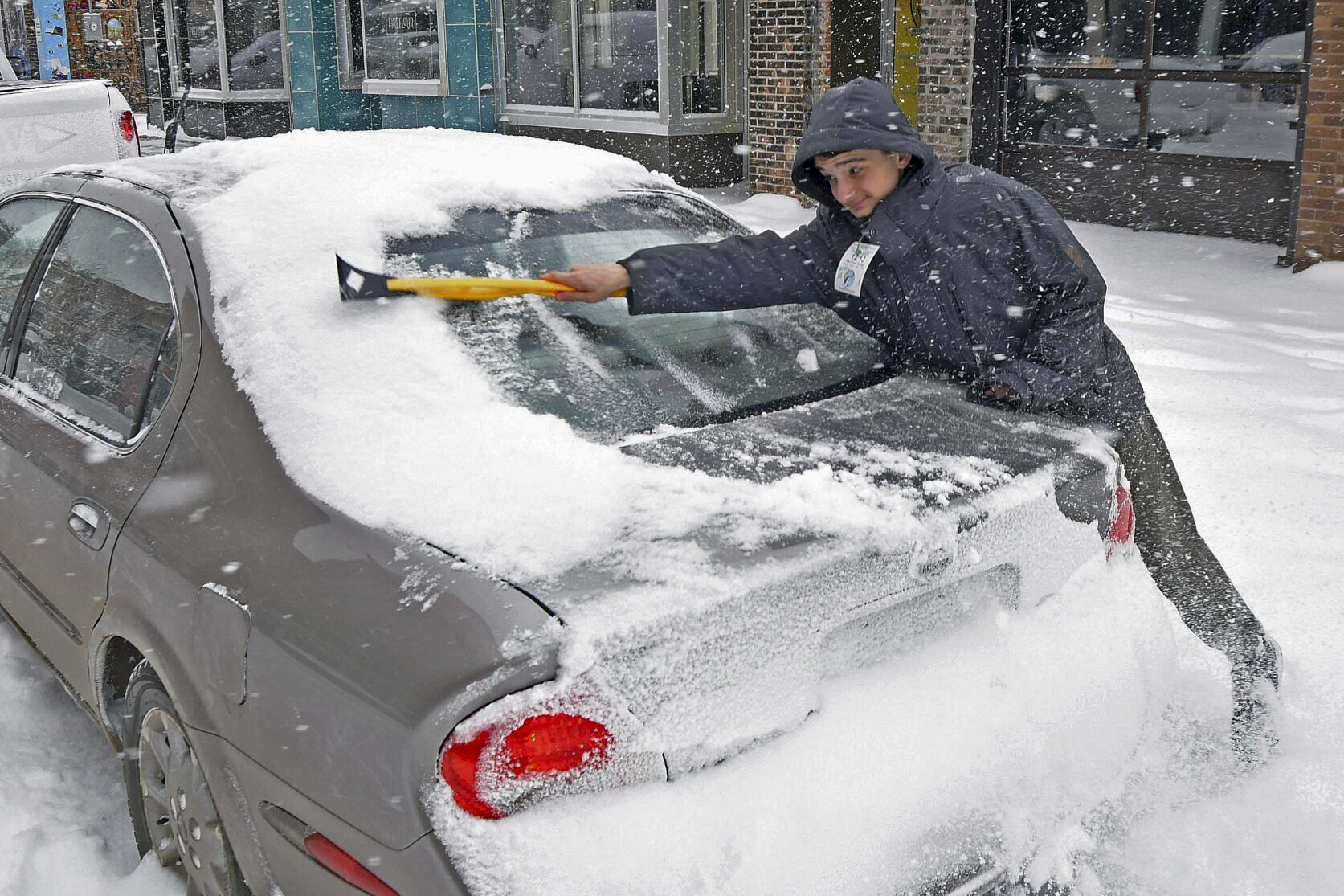 Ayden Ereth brushes snow from his vehicle in downtown Bismarck, N.D., on Tuesday. A monster winter storm took aim at the Upper Midwest on Tuesday, threatening to bring blizzard conditions, bitterly cold temperatures and 2 feet of snow in a three-day onslaught that could affect more than 40 million Americans.